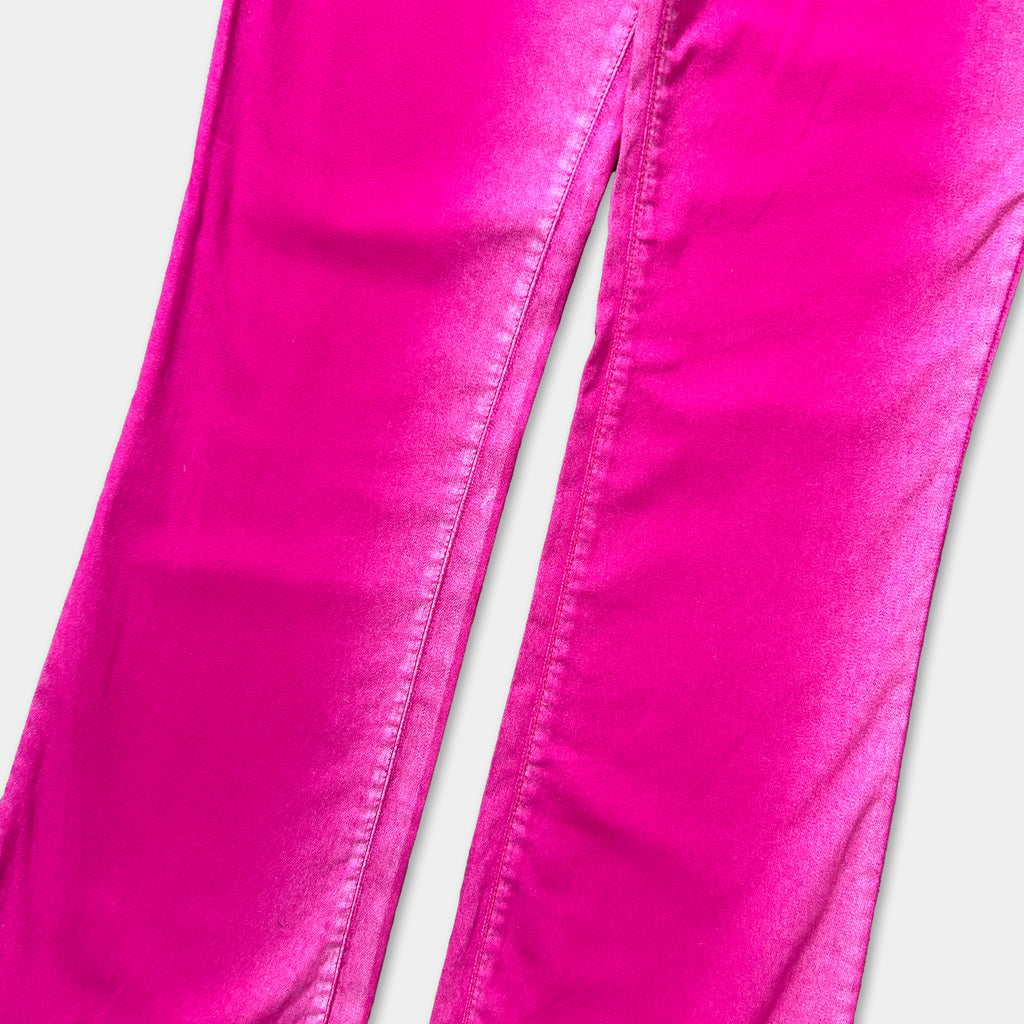 A close-up view of a pair of bright pink jeans against a white background.