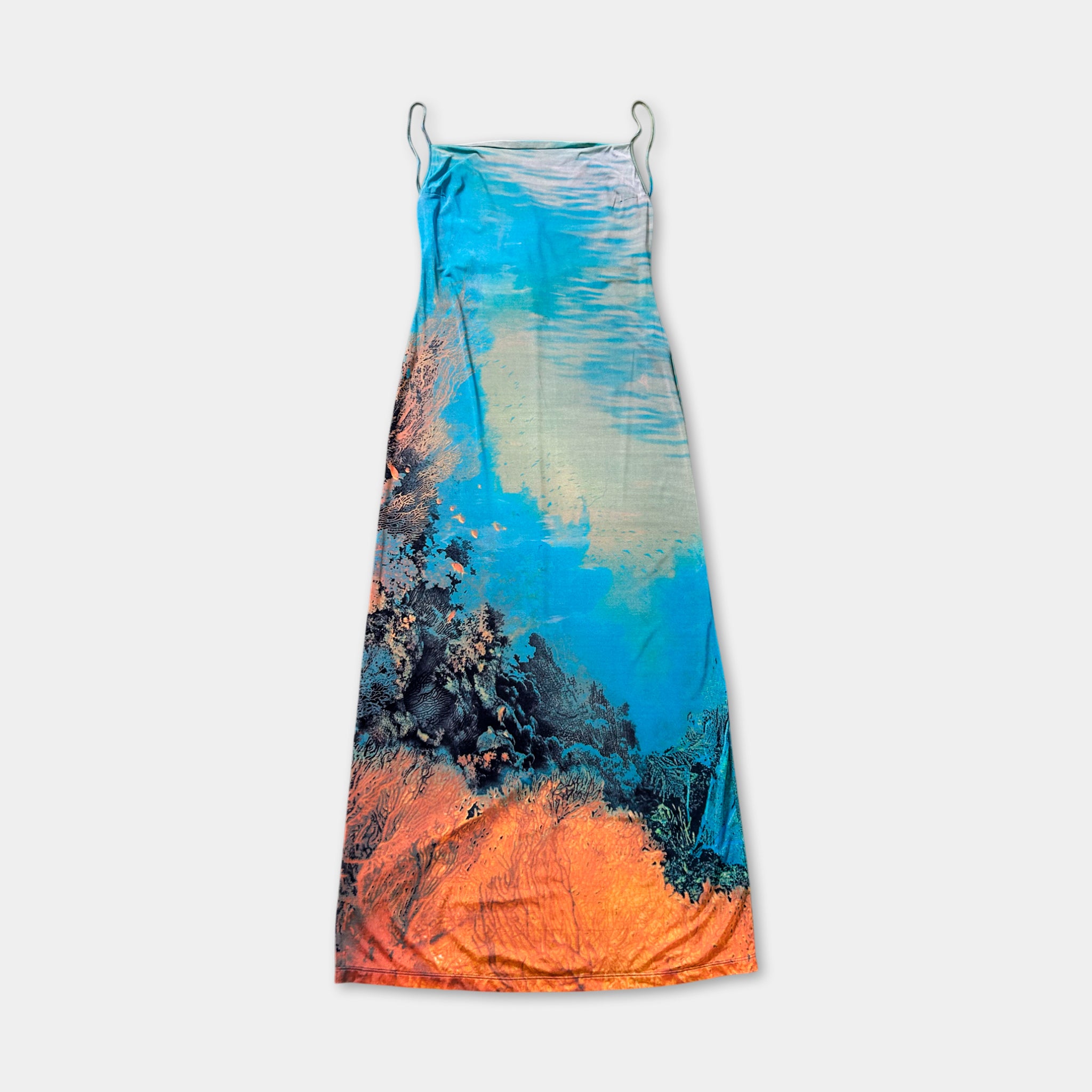 a colorful dress with a vibrant blue and orange pattern, hanging against a plain white background.