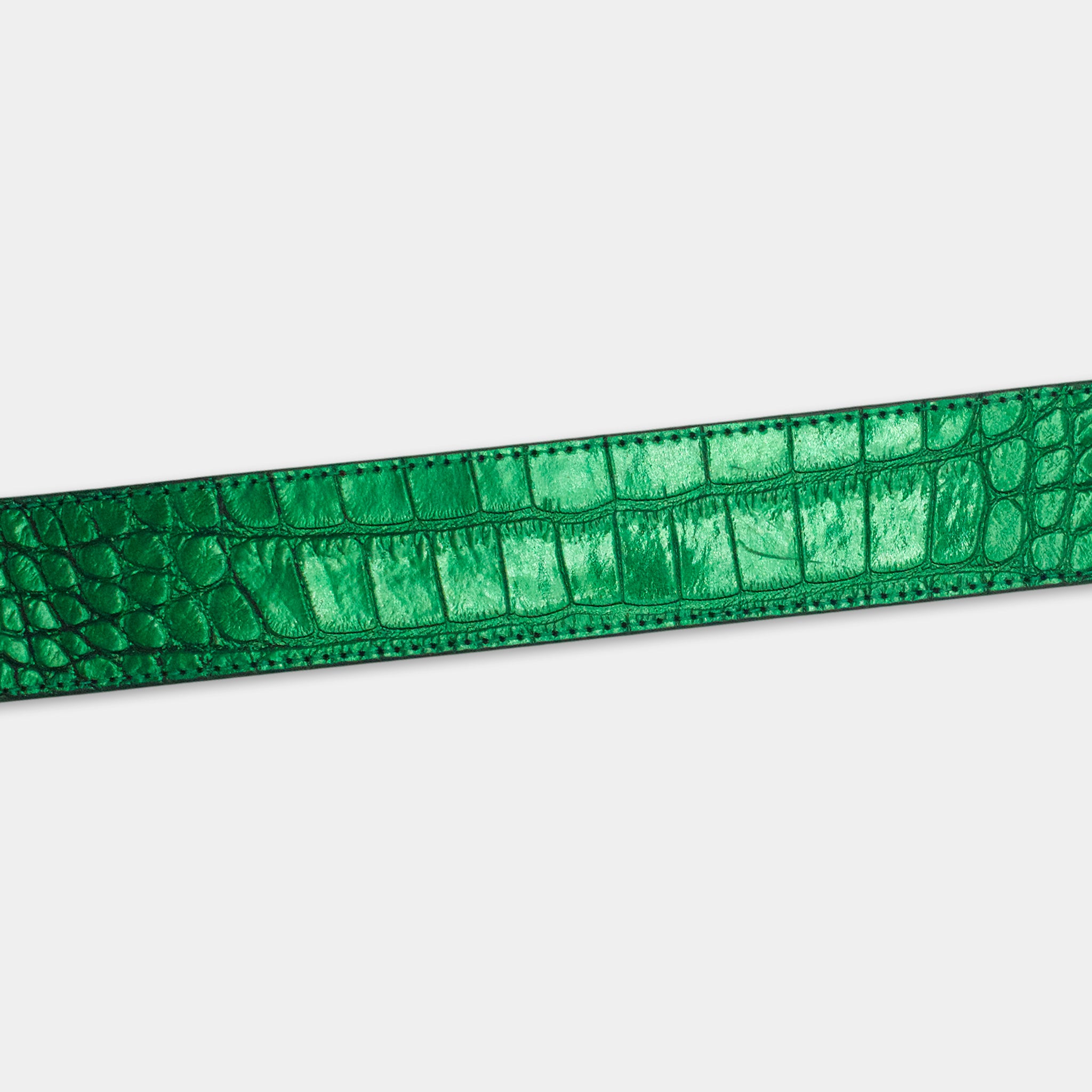 A close-up view of a green, shiny belt with a crocodile skin texture.
