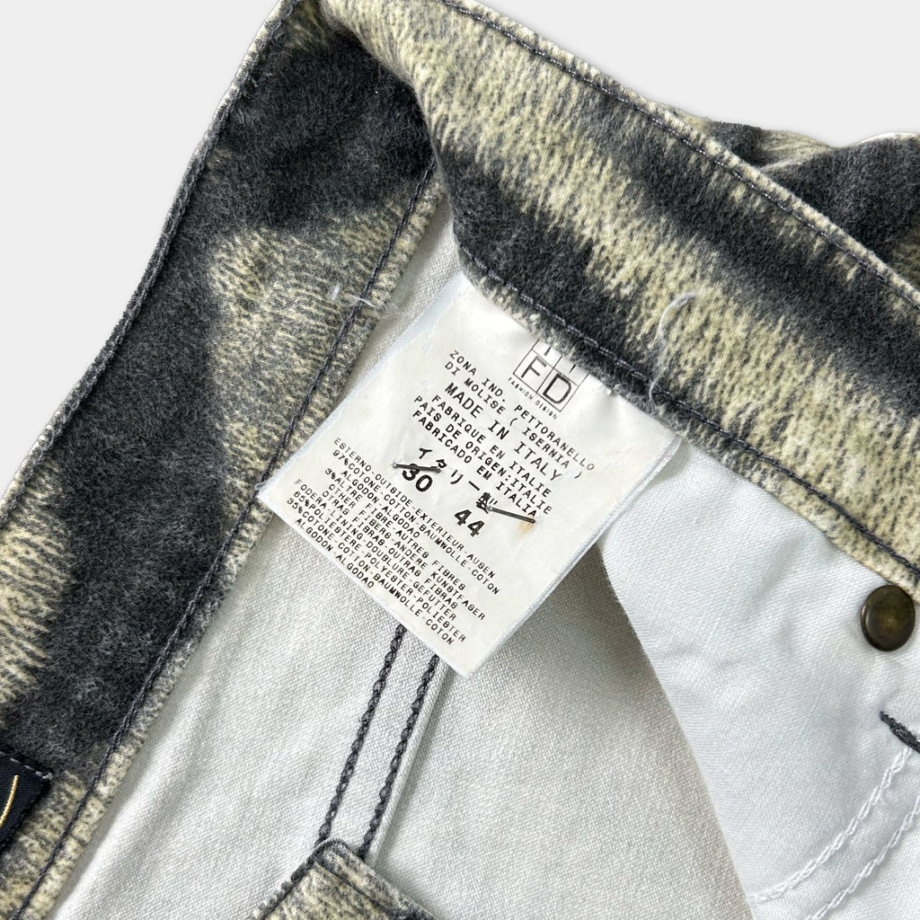a close-up view of a pair of jeans, with a label attached to the waistband.