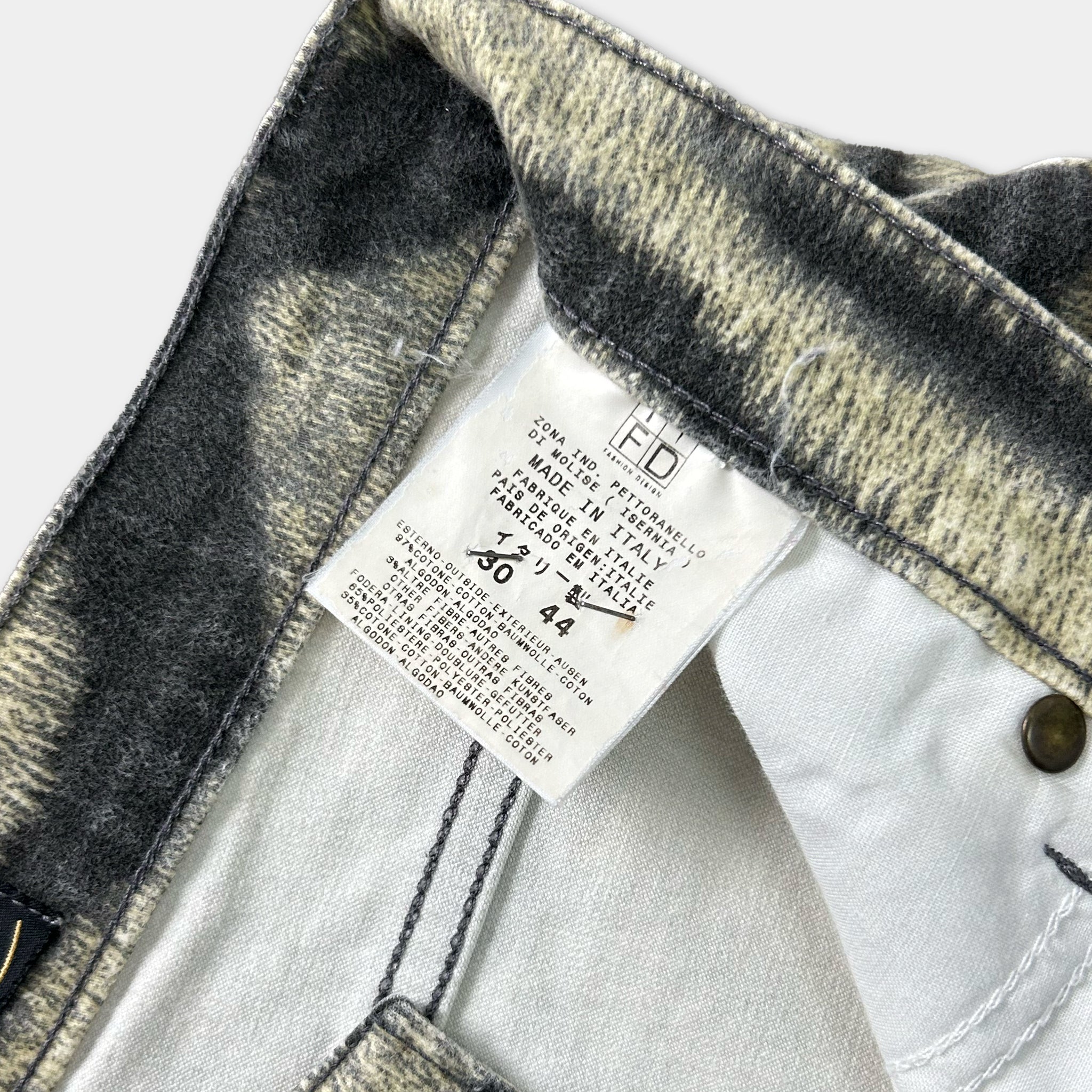a close-up view of a pair of jeans, with a label attached to the waistband.
