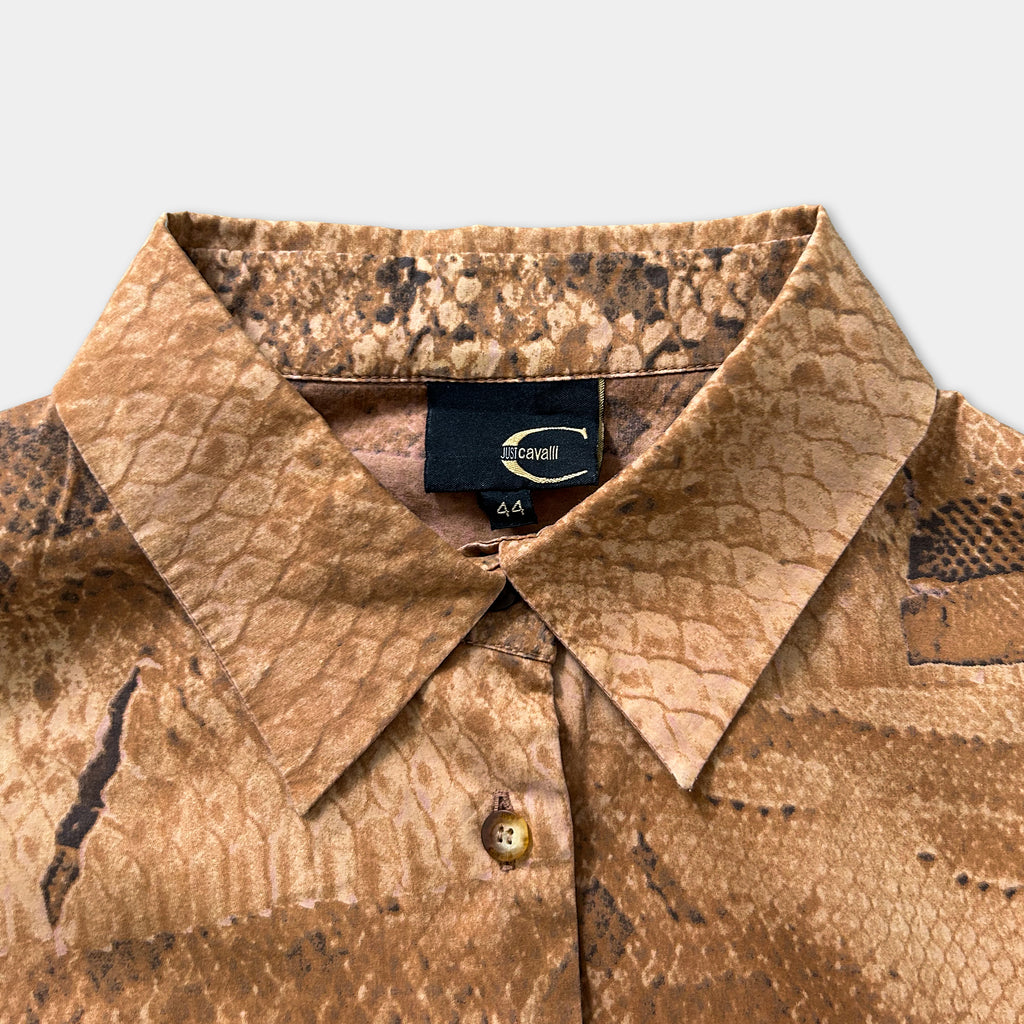 a close-up view of a brown, patterned shirt collar with a label attached to it.