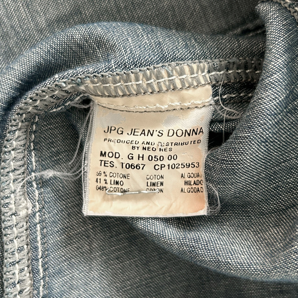 a close-up view of a denim fabric, with a label attached to it. The label provides information about the denim fabric, including details about its production, material, and origin.