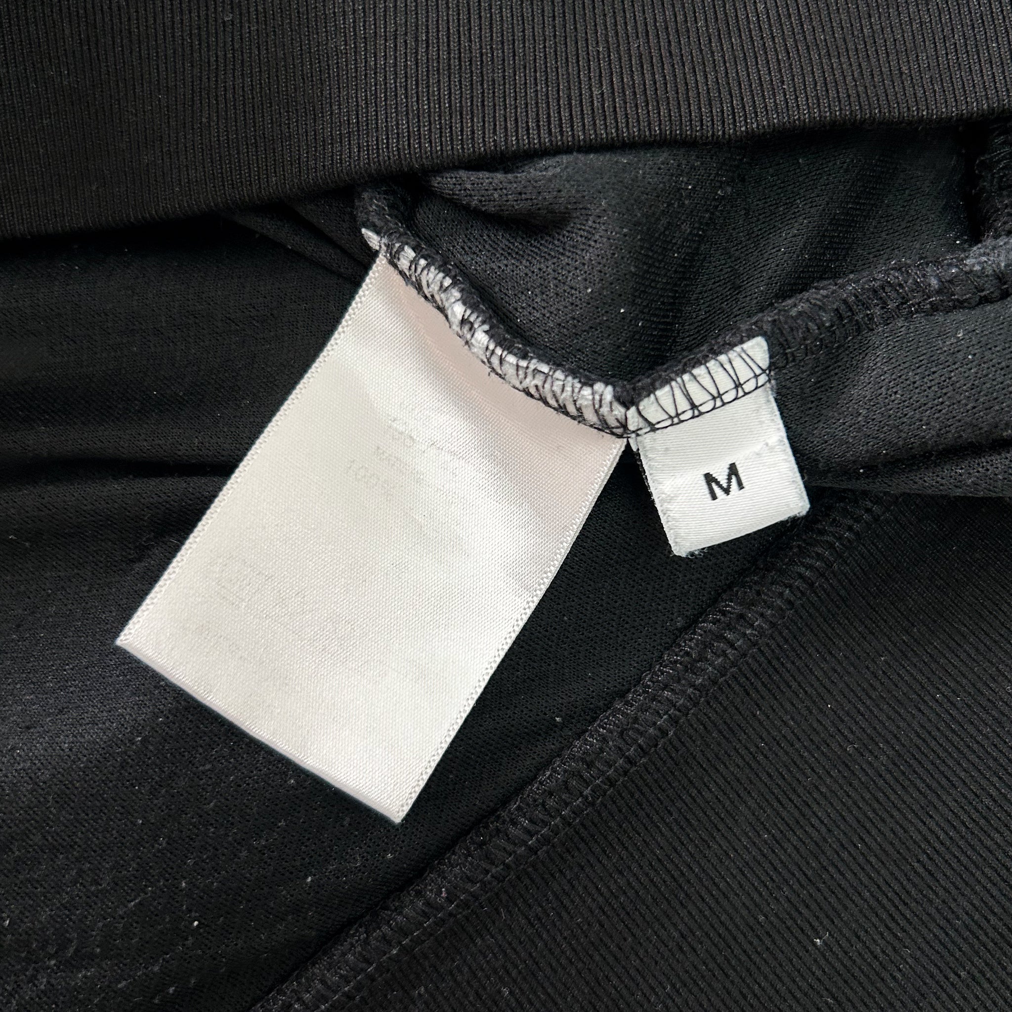 a close-up view of a black fabric with a white label attached to it.