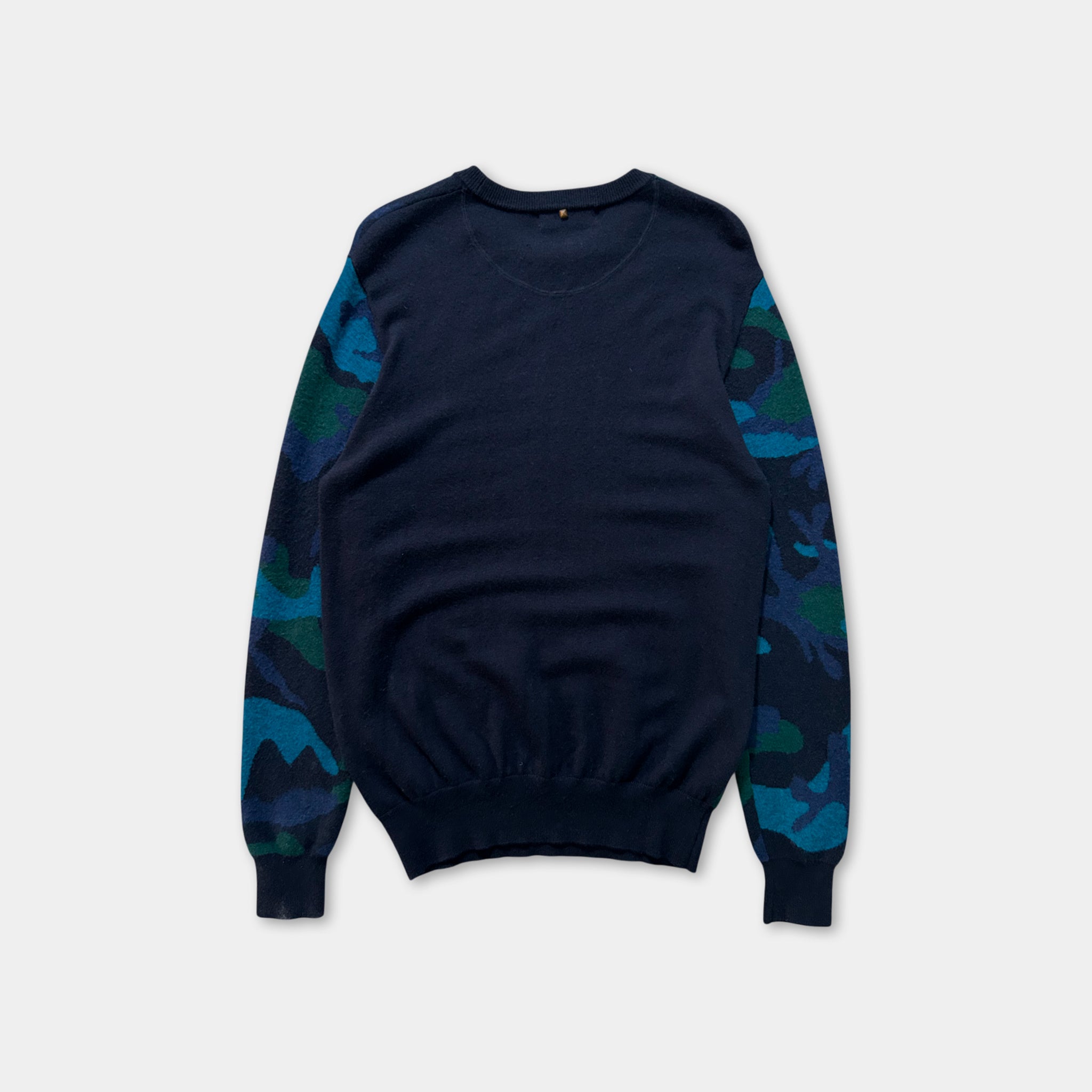 A navy blue long-sleeved sweater with camouflage patterns on the sleeves.