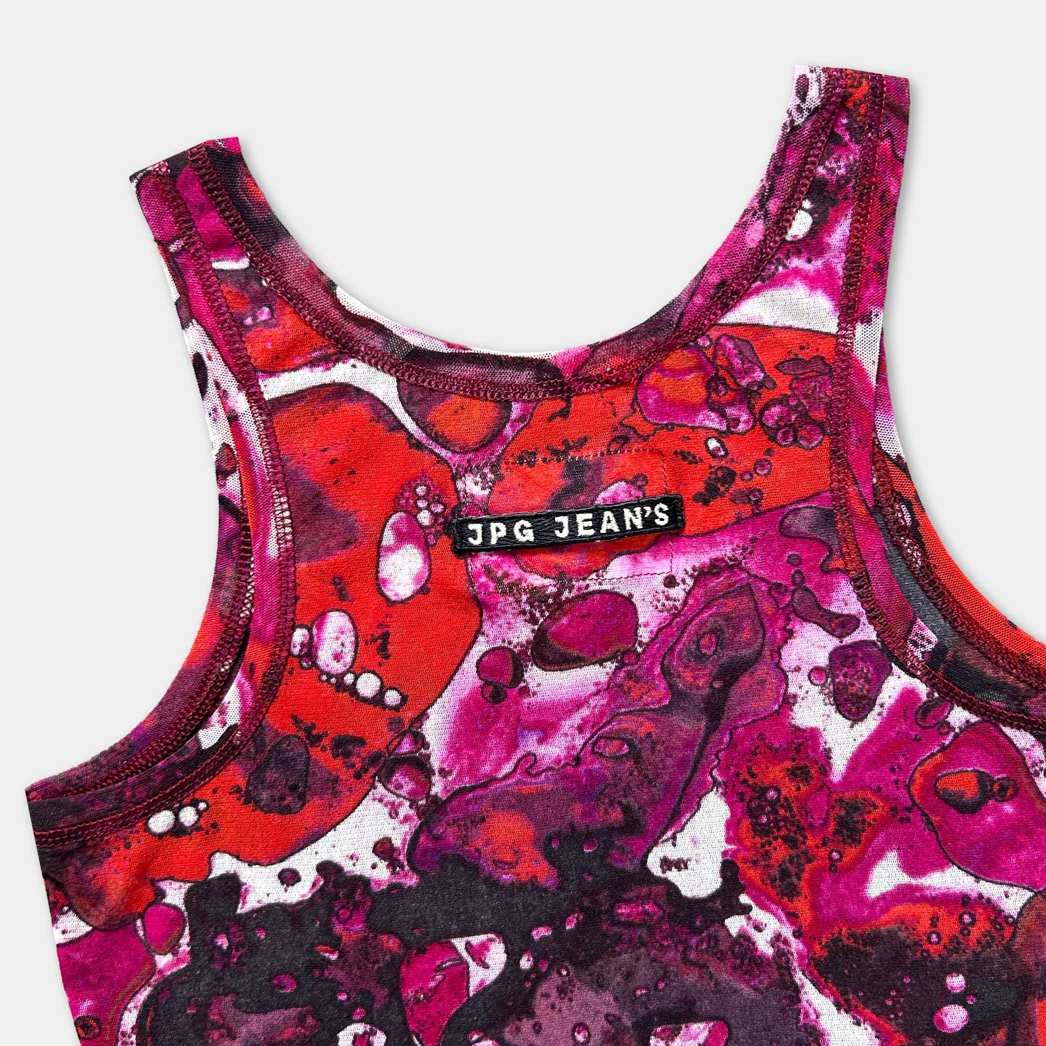 A colorful tank top with a vibrant abstract pattern in shades of red, pink, and purple.