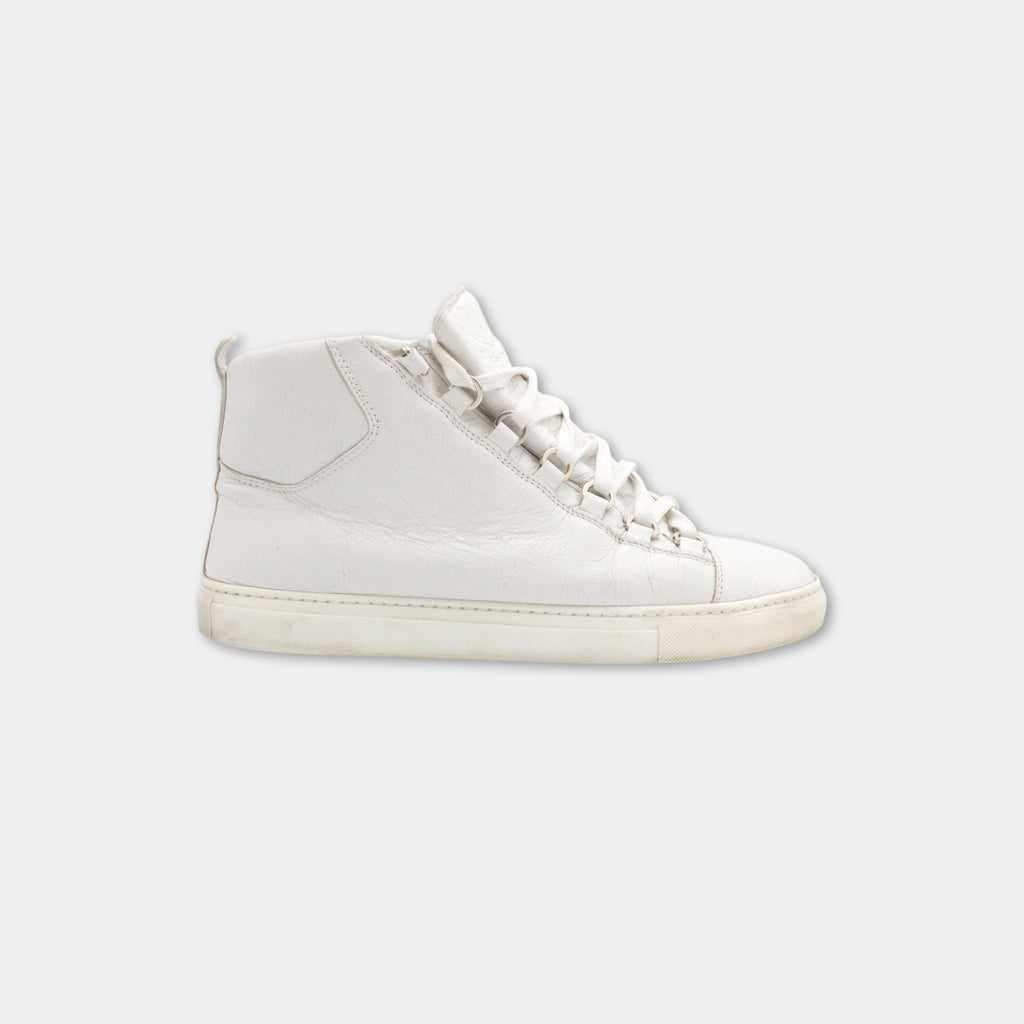 A white sneaker with a low top and laces, shown against a plain background.