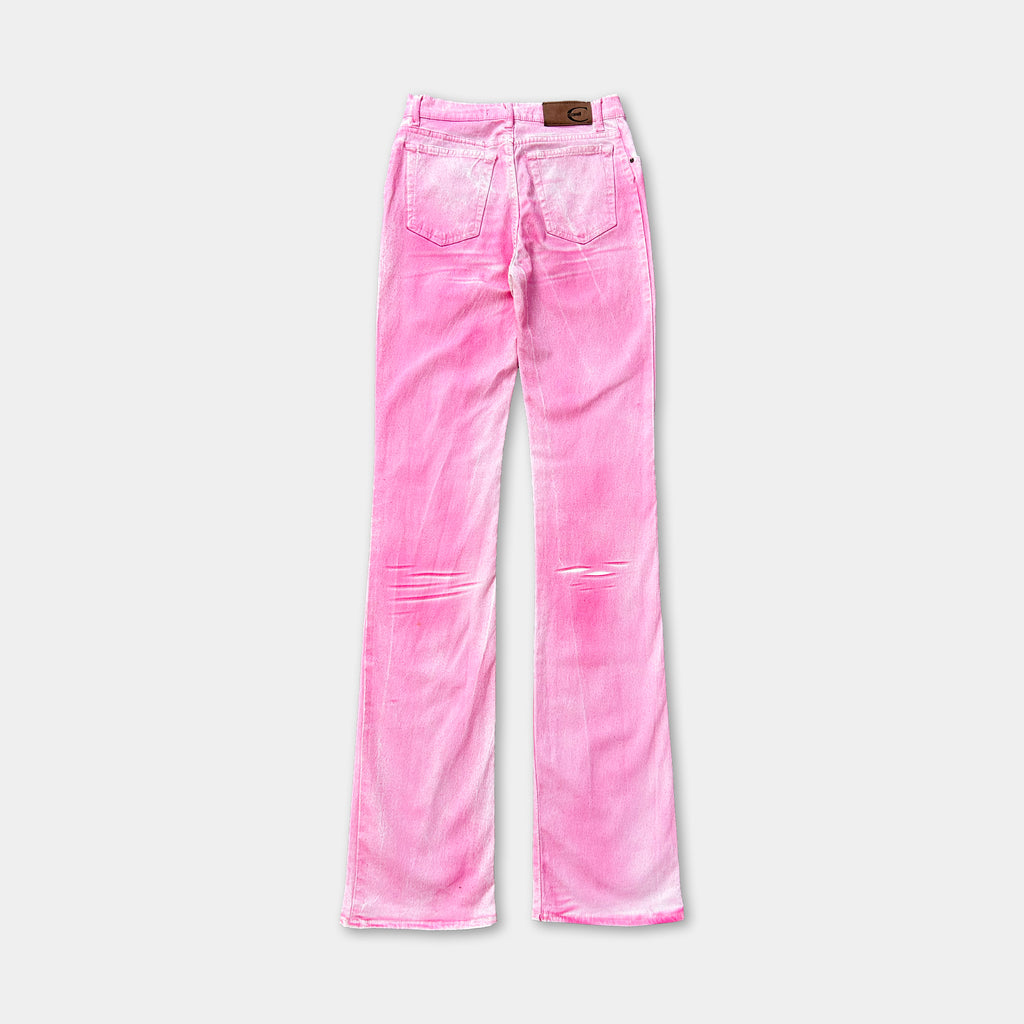 A pair of pink jeans with a brown leather patch on the back pocket.