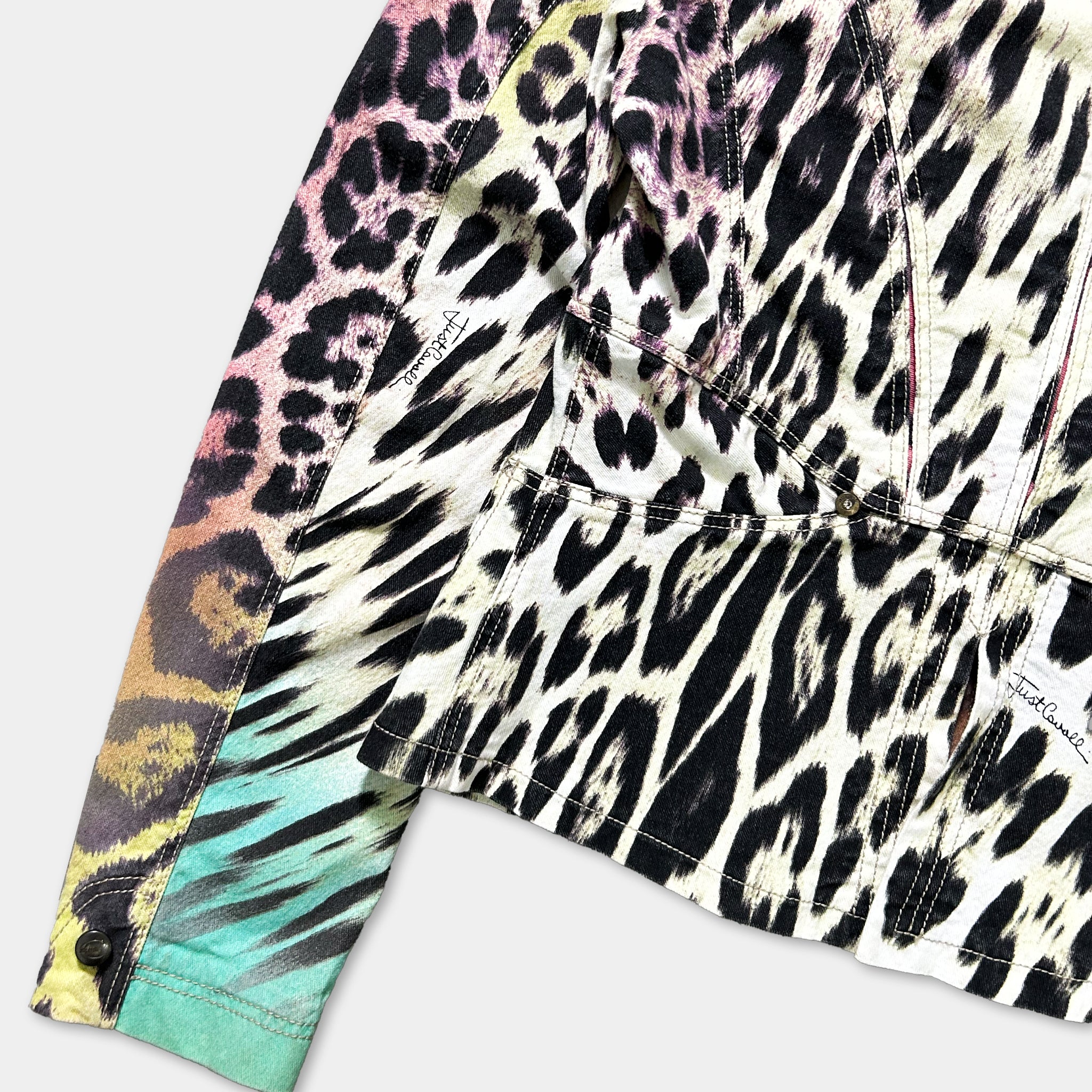 a close-up view of a jacket with a leopard print pattern. The jacket appears to be a colorful and vibrant piece of clothing, featuring a mix of black, white, and other bold colors.