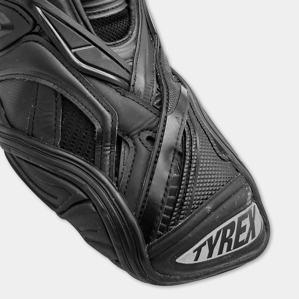 A close-up view of a black and white shoe with the brand name "TYREX" visible on the side.