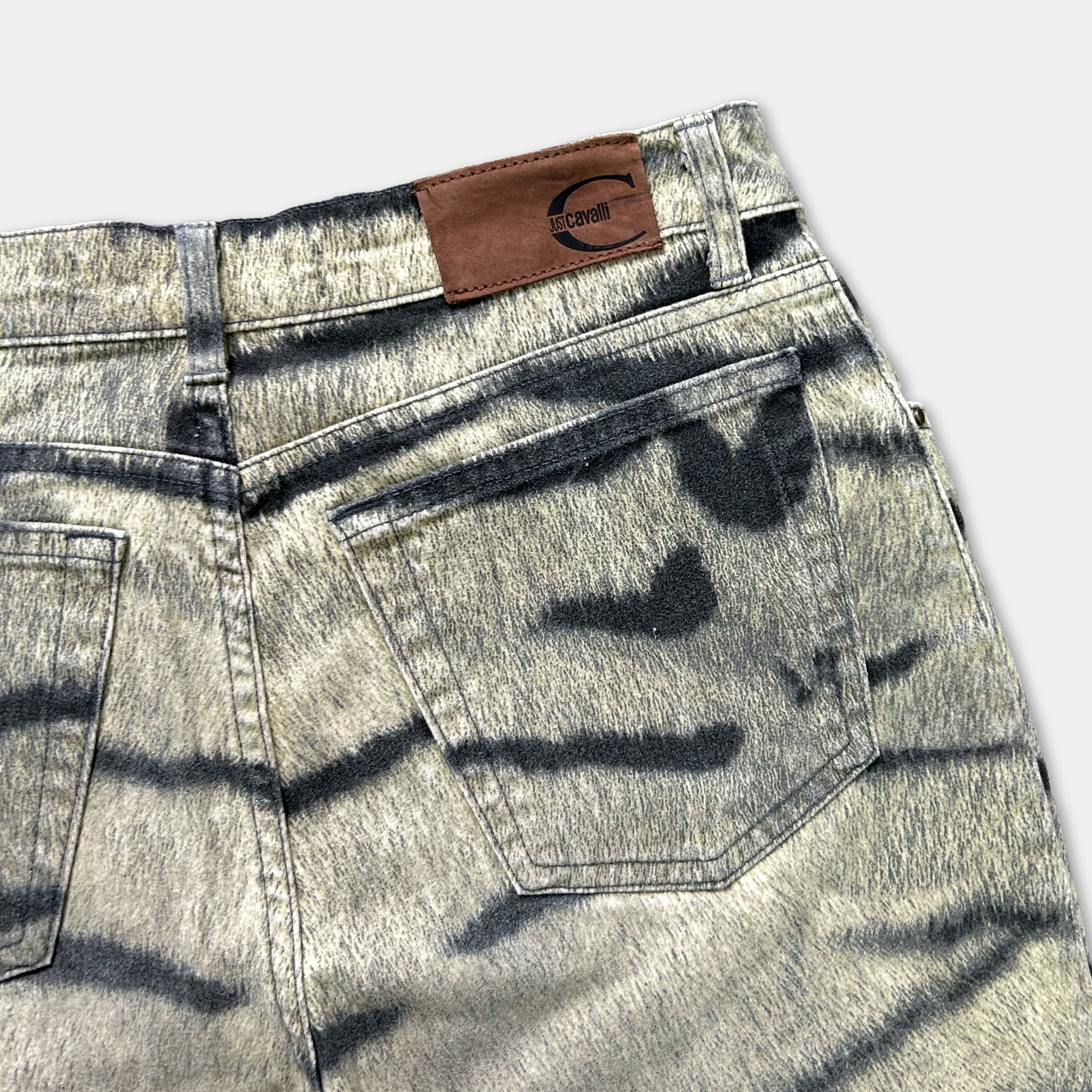 A pair of gray and black striped jeans with a brown leather patch on the waistband.