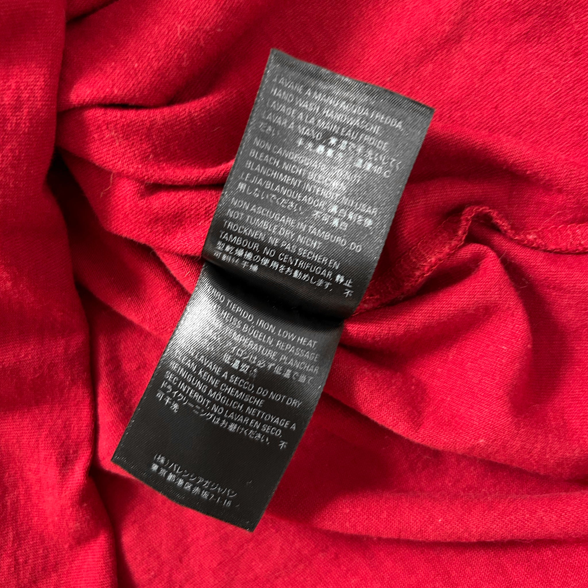 a close-up view of a black label with text on a red fabric background.