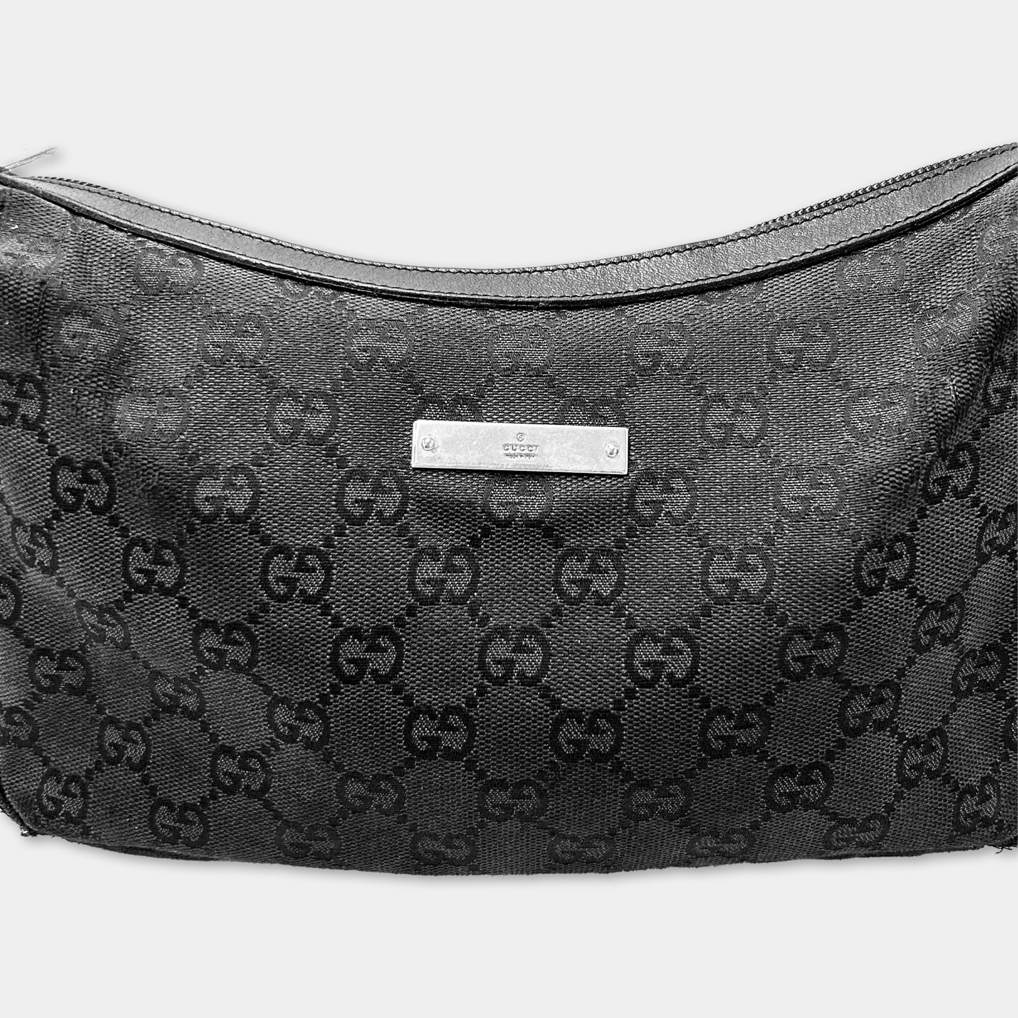 A black Gucci handbag with a distinctive monogram pattern.
