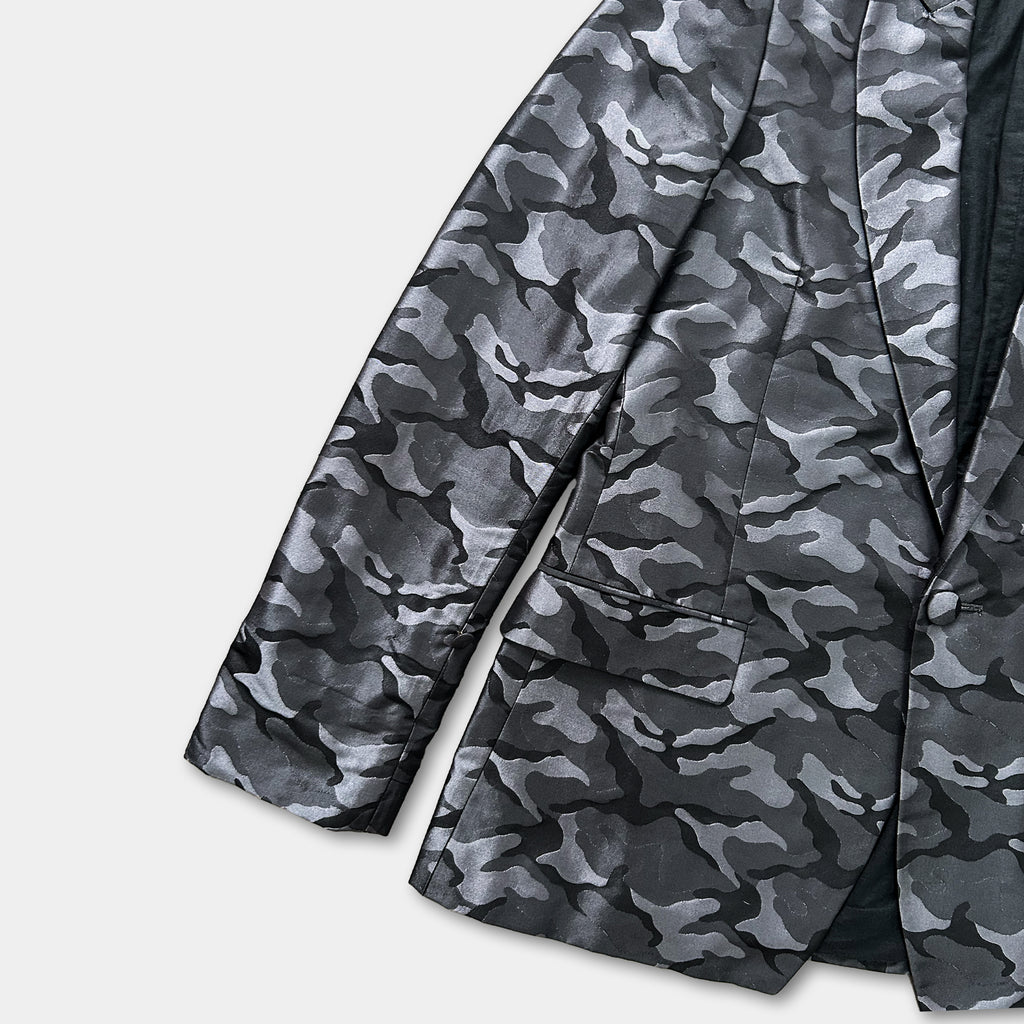A black and grey camouflage jacket with a pattern of small, indistinct shapes.