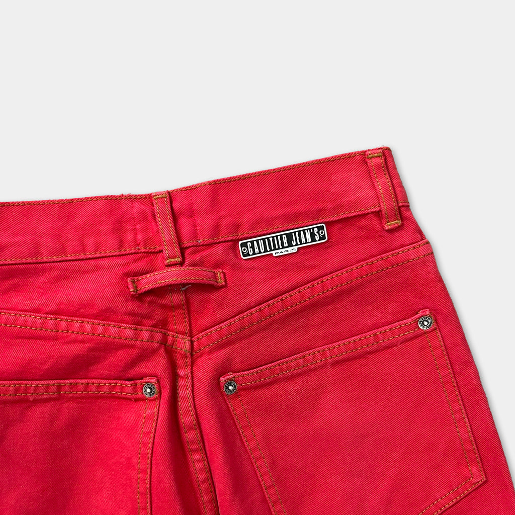 A pair of bright red jeans with a label on the back pocket.
