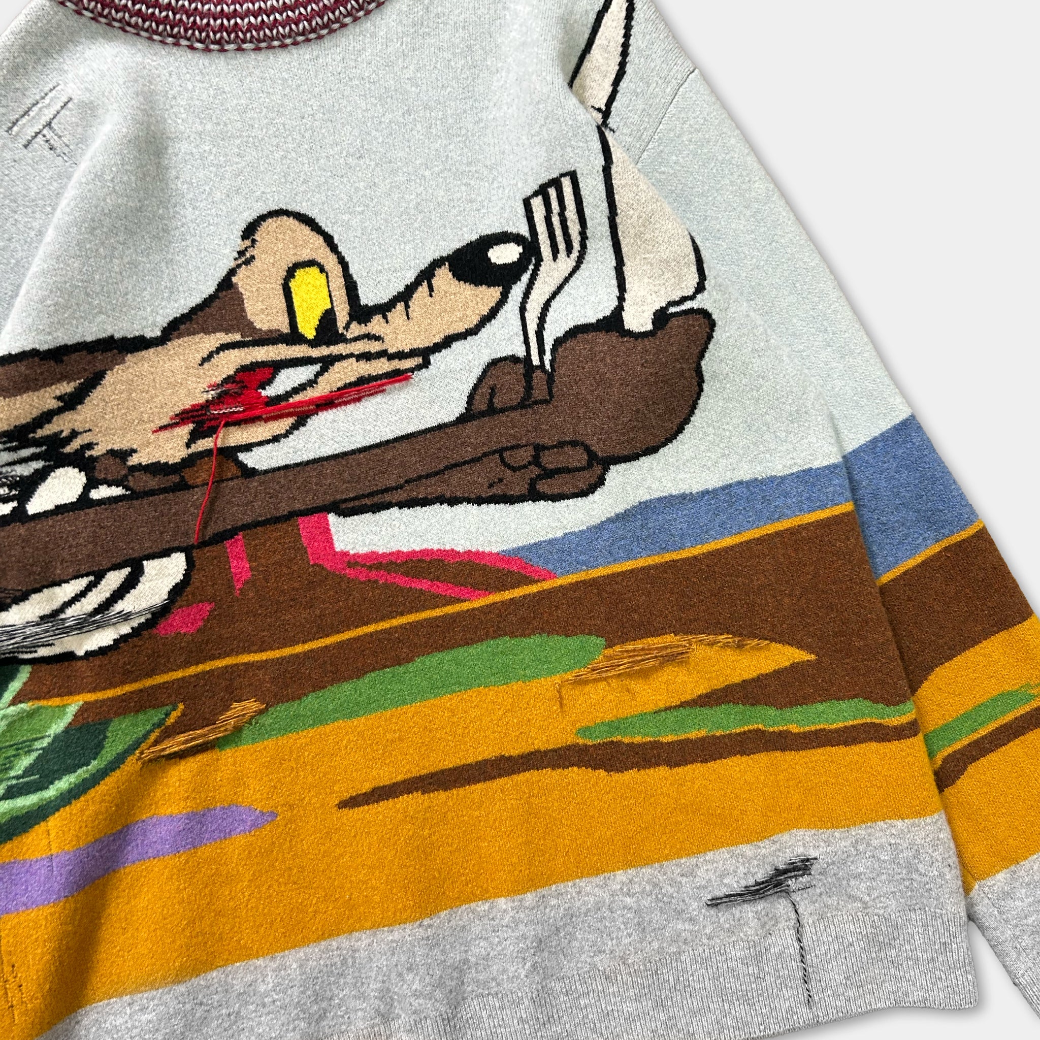 a colorful, cartoon-style sweater with a large, cartoon-like character on the front.