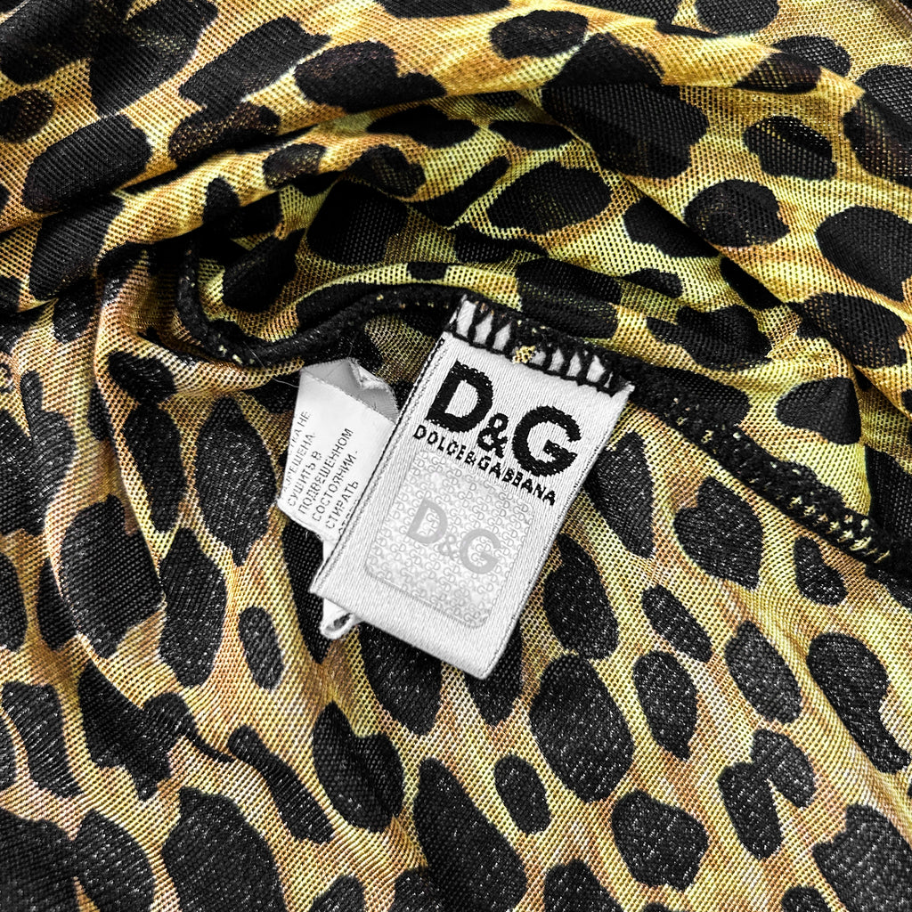 a close-up view of a leopard print fabric with a white label attached to it, displaying the D&G logo.