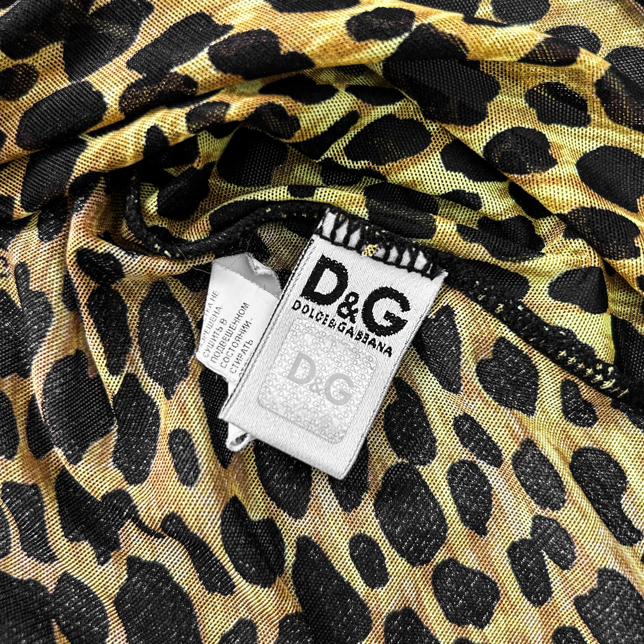 a close-up view of a leopard print fabric with a white label attached to it, displaying the D&G logo.