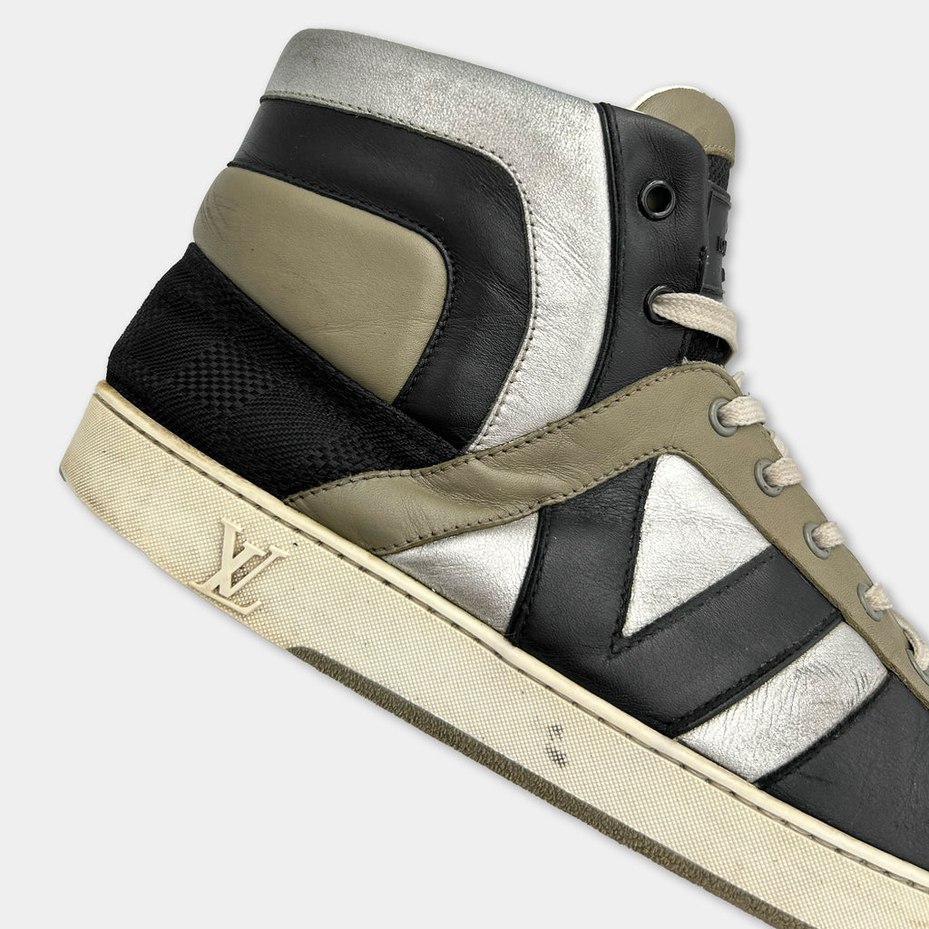 A close-up of a high-top sneaker with a black, gray, and white color scheme.
