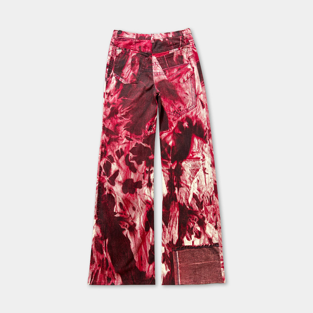 A pair of red and white patterned jeans with a bold, abstract design.