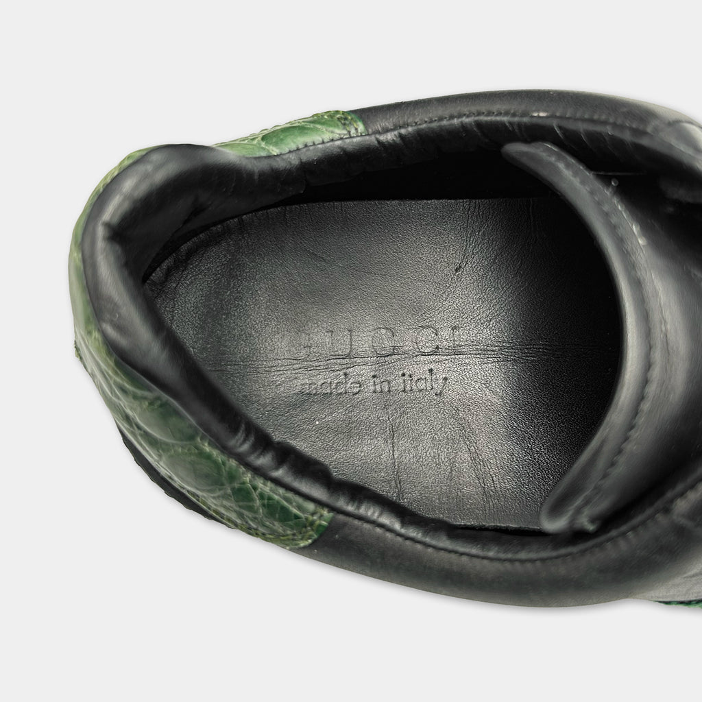 A close-up view of a black leather shoe with a green pattern on the side.