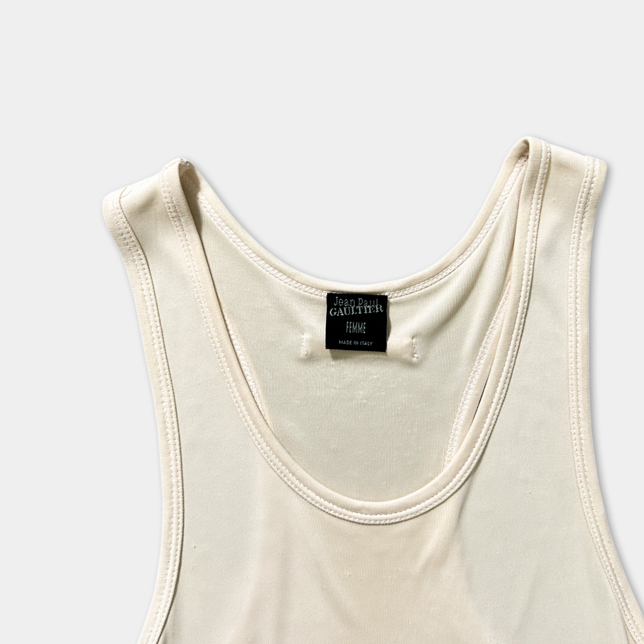 A white tank top with a label on the neckline.
