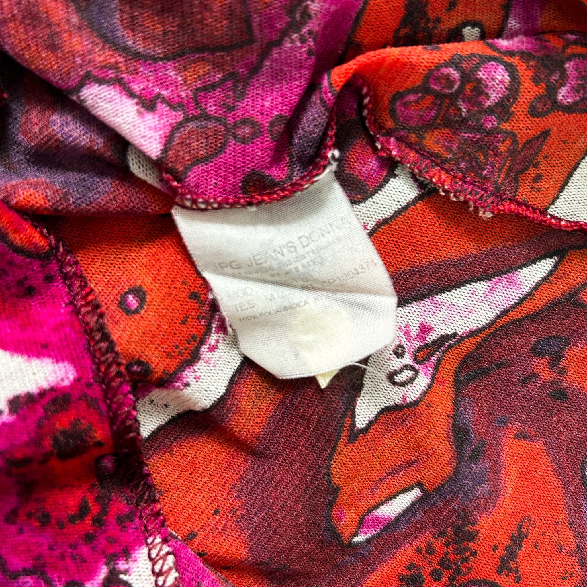 a close-up view of a colorful, patterned fabric with a white label attached to it.