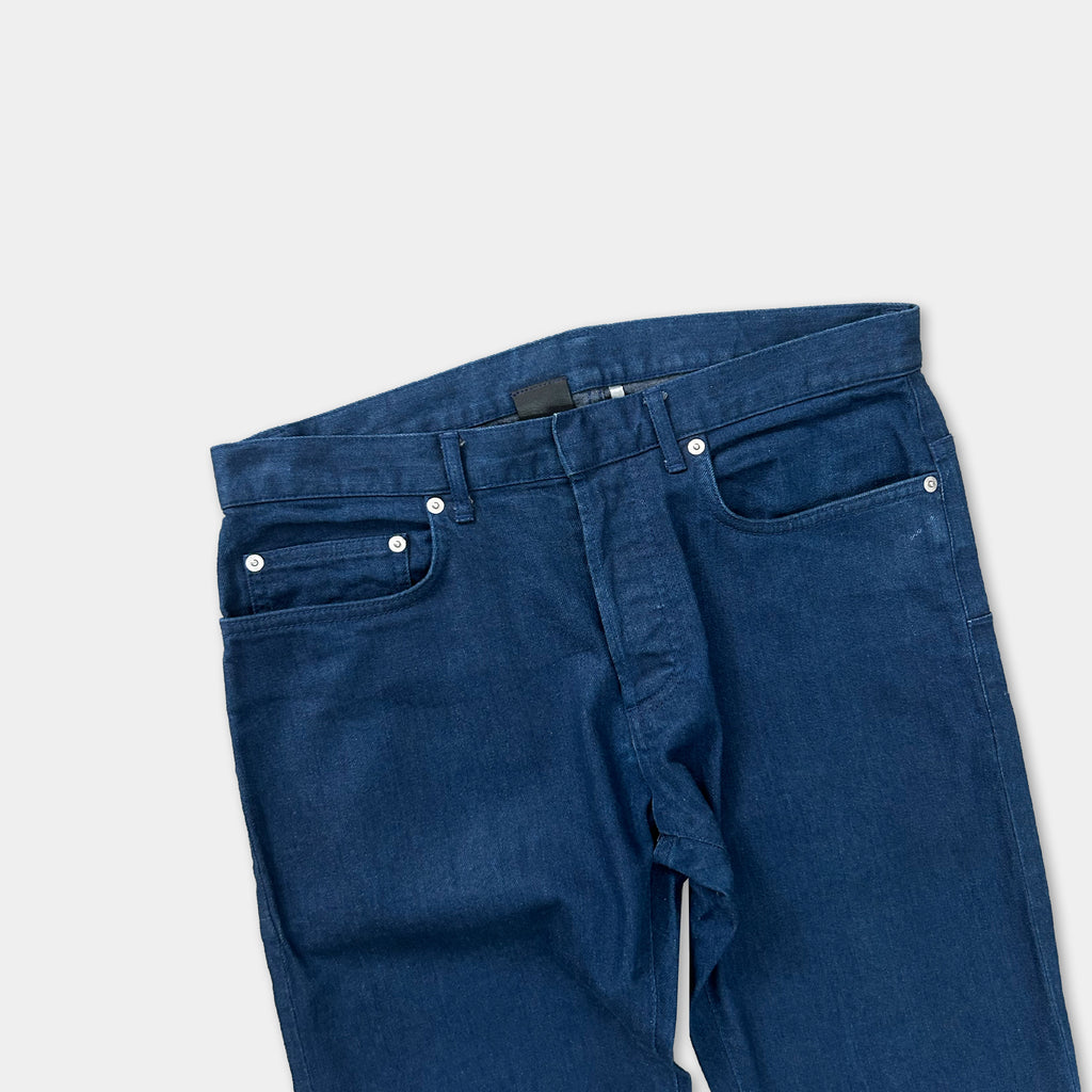 A pair of blue jeans with a black belt and white buttons.