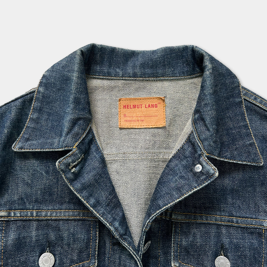 A close-up view of a denim jacket with a label on the collar.