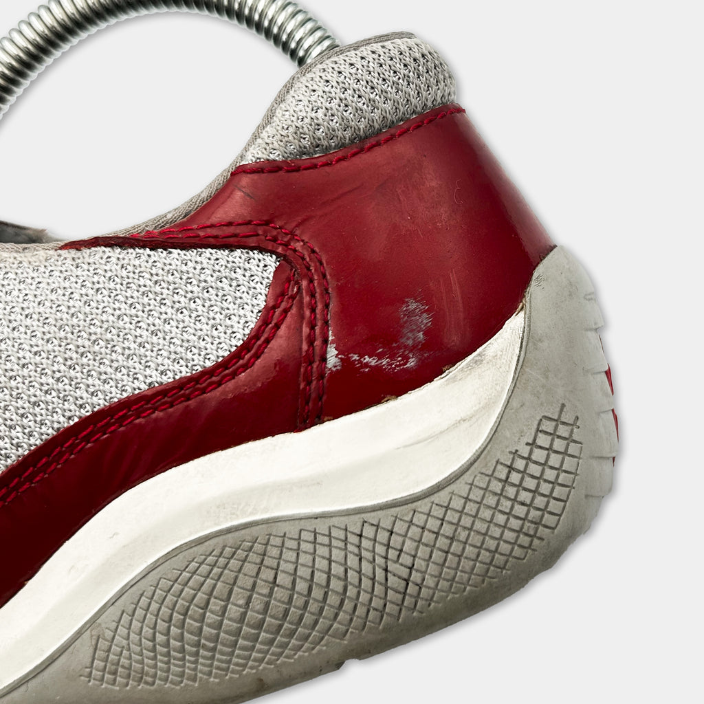A close-up view of a red and white athletic shoe with a textured sole.