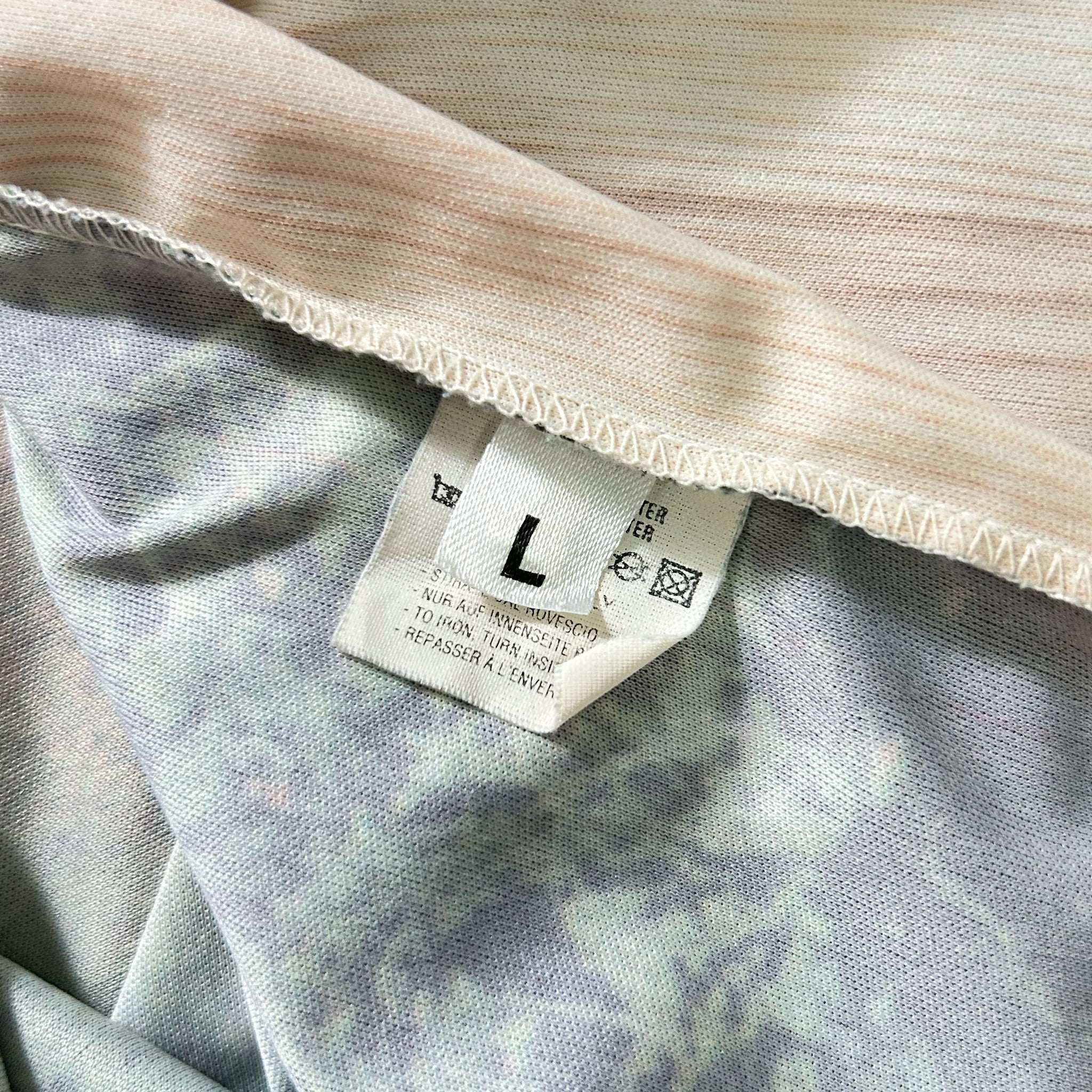 a close-up view of a fabric label with text and symbols, likely providing information about the product or care instructions.