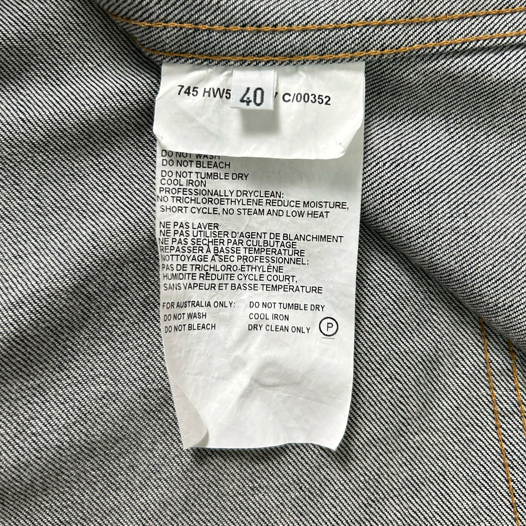 a close-up view of a label on a piece of clothing, likely a denim garment, with text detailing the care instructions for the garment.