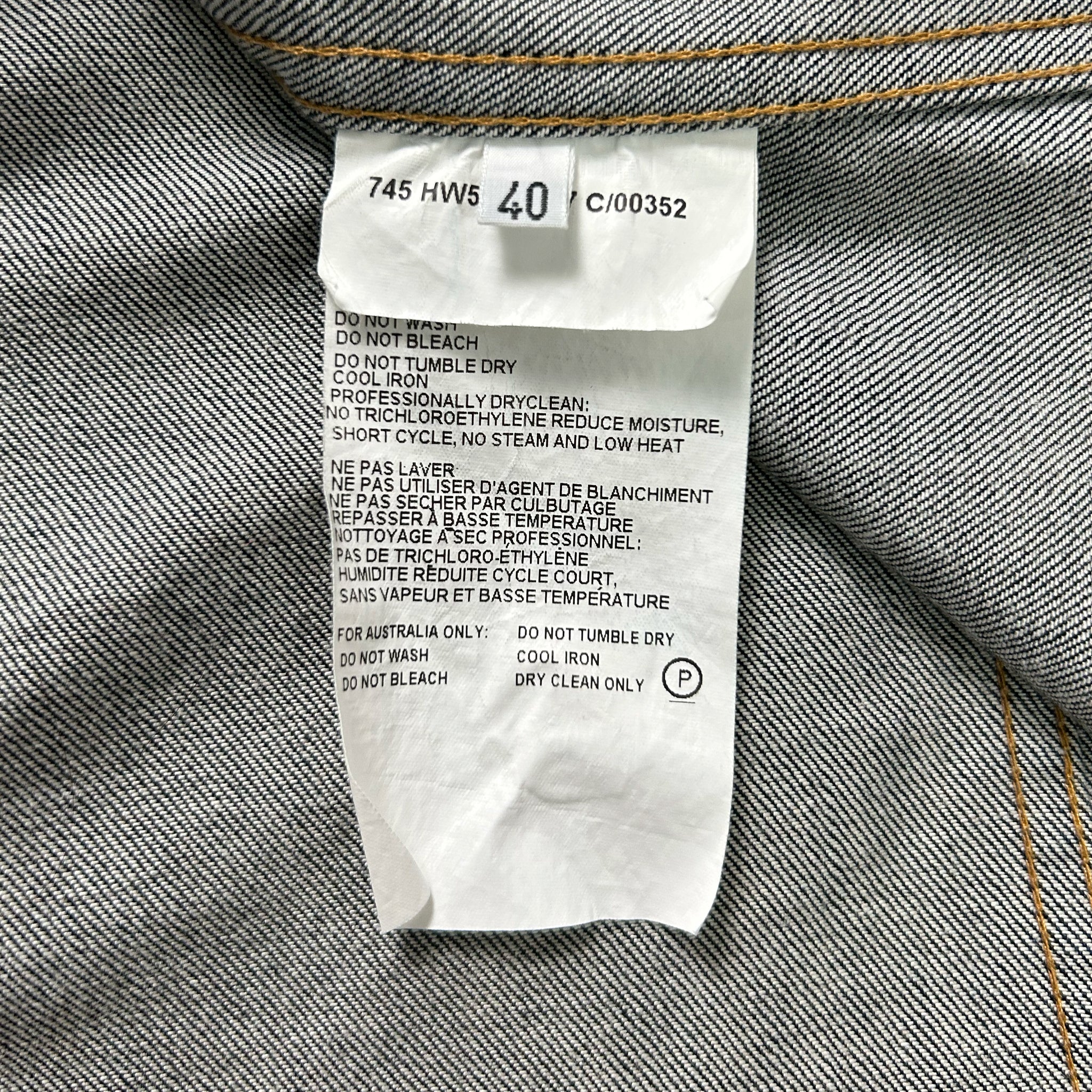 a close-up view of a label on a piece of clothing, likely a denim garment, with text detailing the care instructions for the garment.