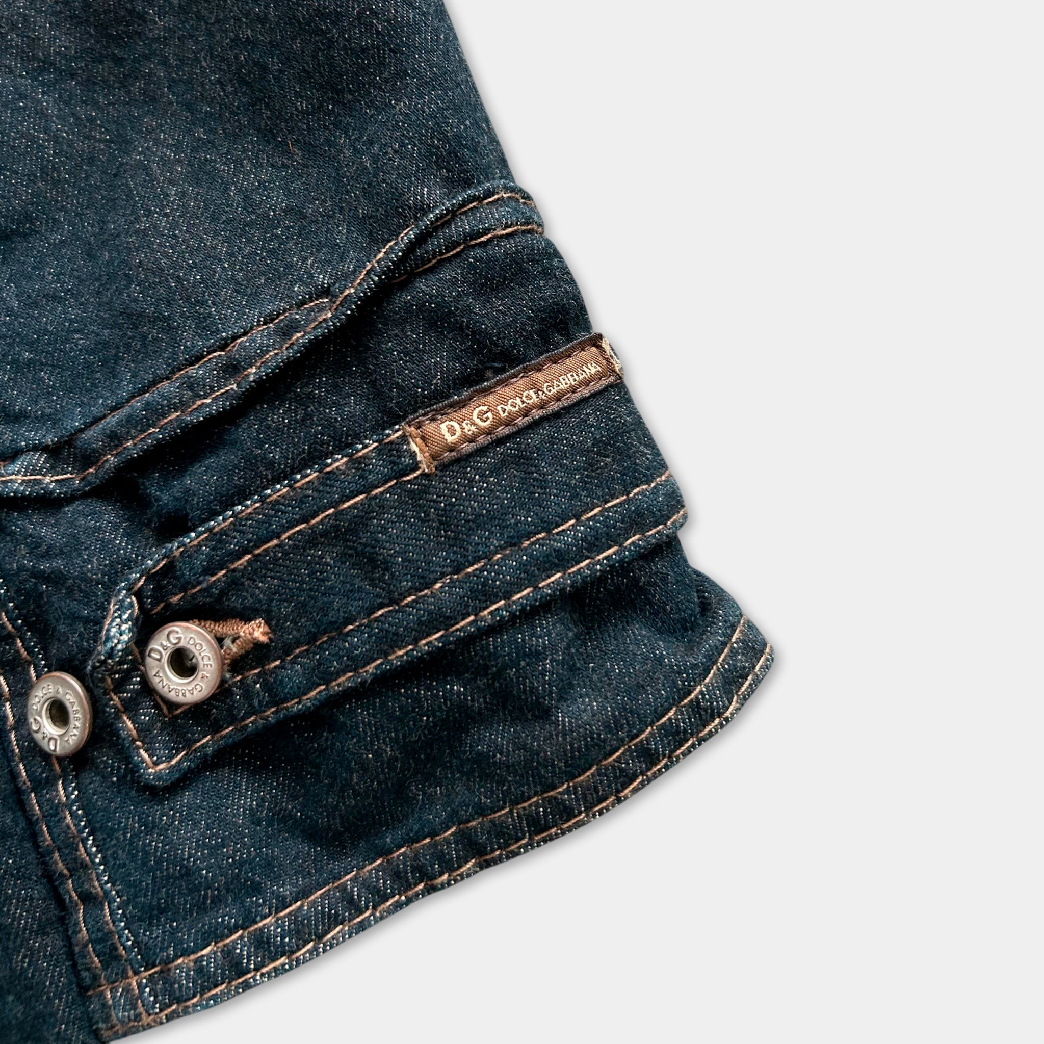 A close-up view of a pocket on a pair of blue jeans, with a label or tag attached to it.
