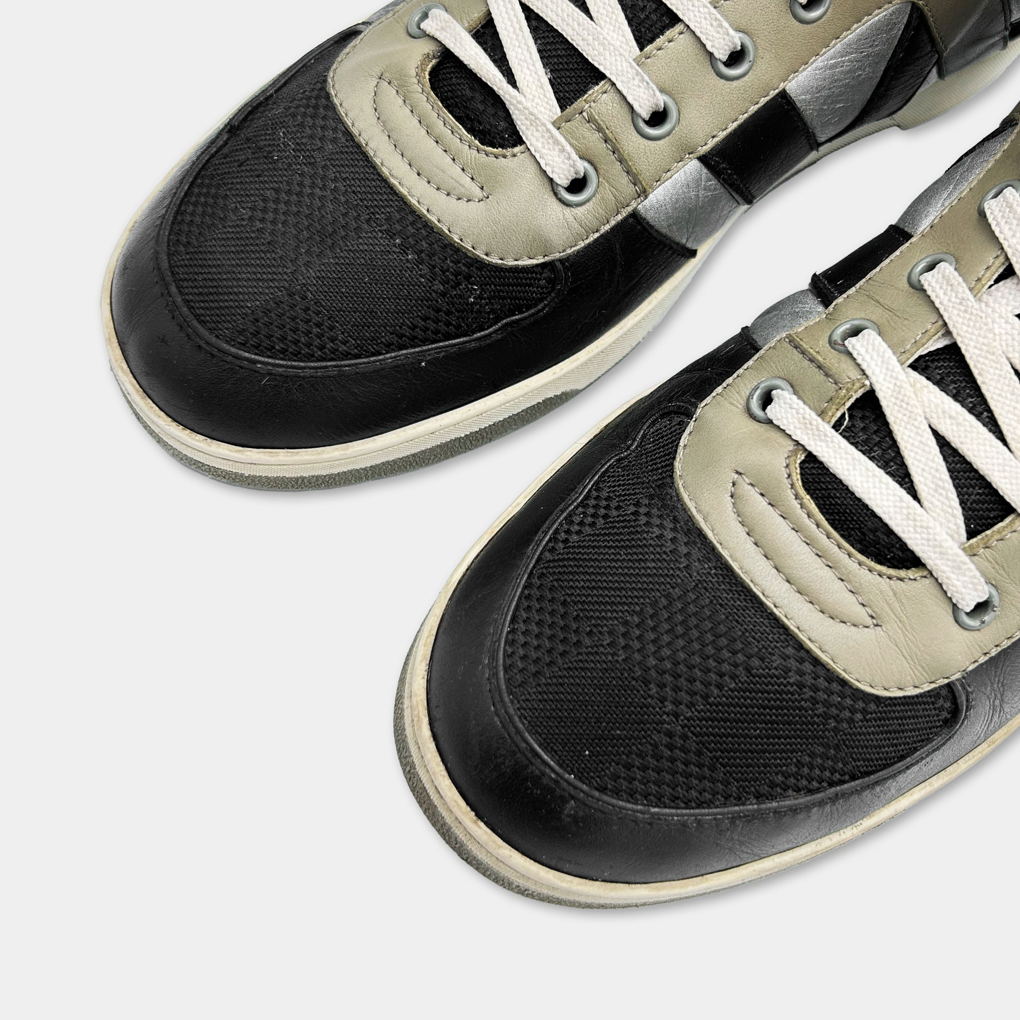 A close-up view of a pair of black and gray sneakers with white laces.