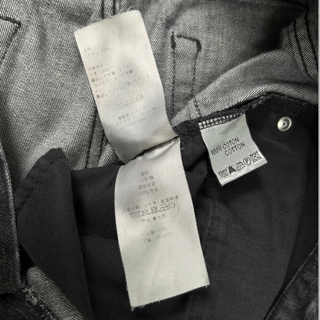 a close-up view of a garment, possibly a pair of jeans, with a label attached to it. The label appears to contain information about the garment, such as the material and care instructions.