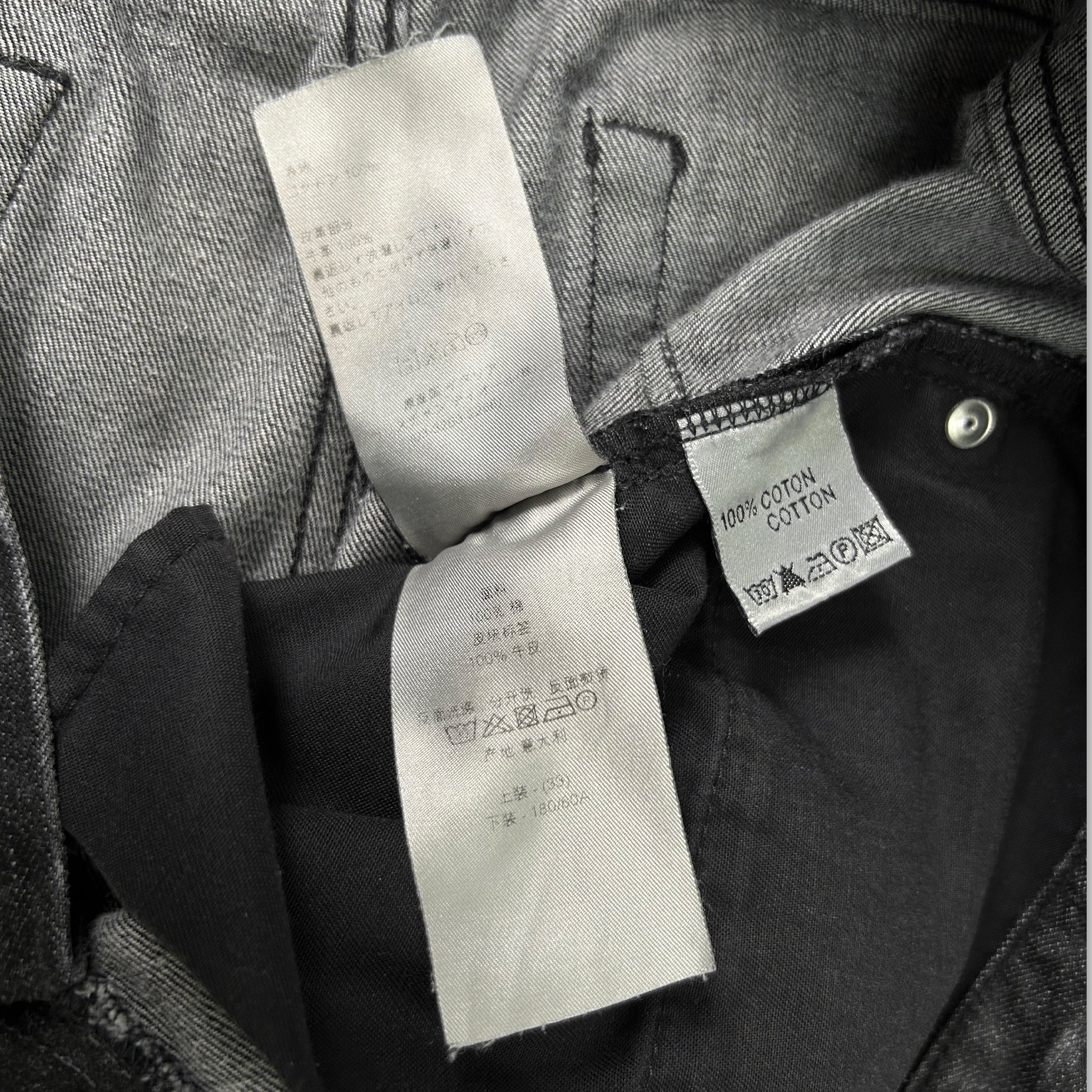 a close-up view of a garment, possibly a pair of jeans, with a label attached to it. The label appears to contain information about the garment, such as the material and care instructions.