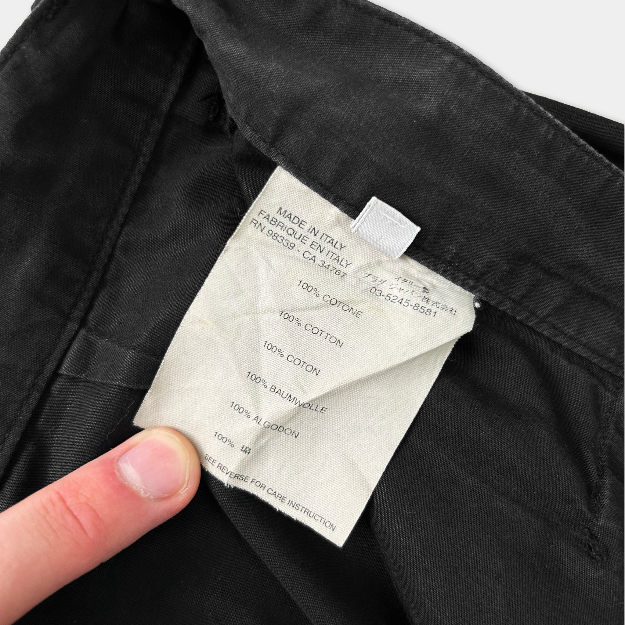 A close-up view of a black fabric, possibly a piece of clothing, with a label attached to it.