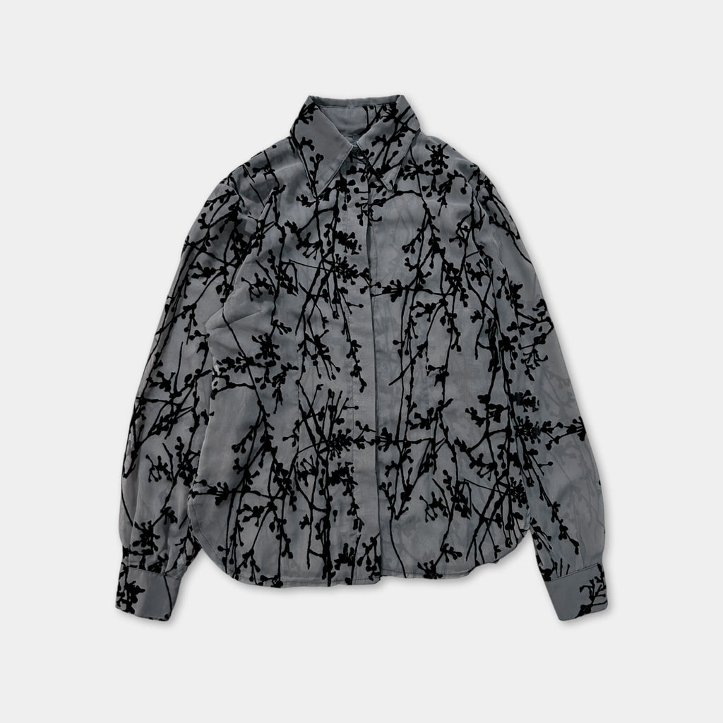 a gray shirt with a black leaf pattern.