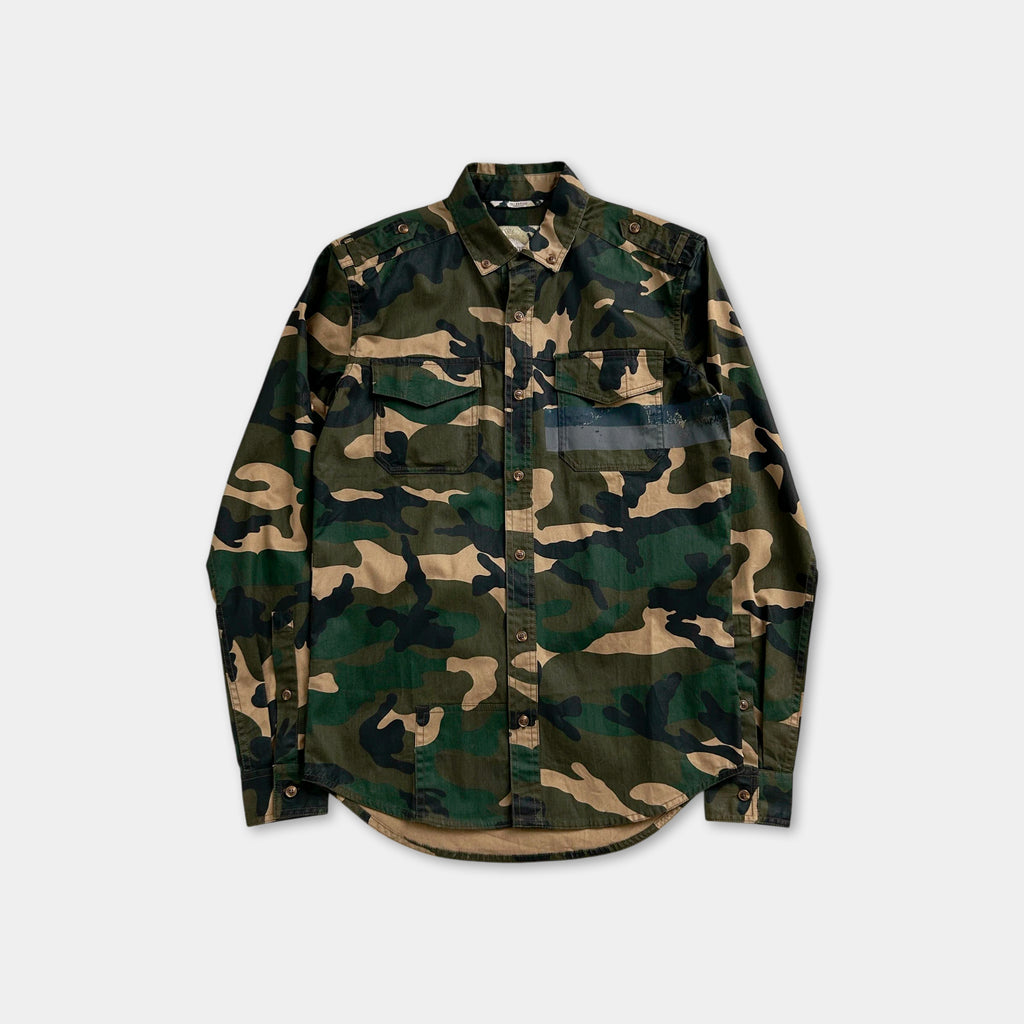 A camouflage-patterned long-sleeved shirt is displayed against a white background.