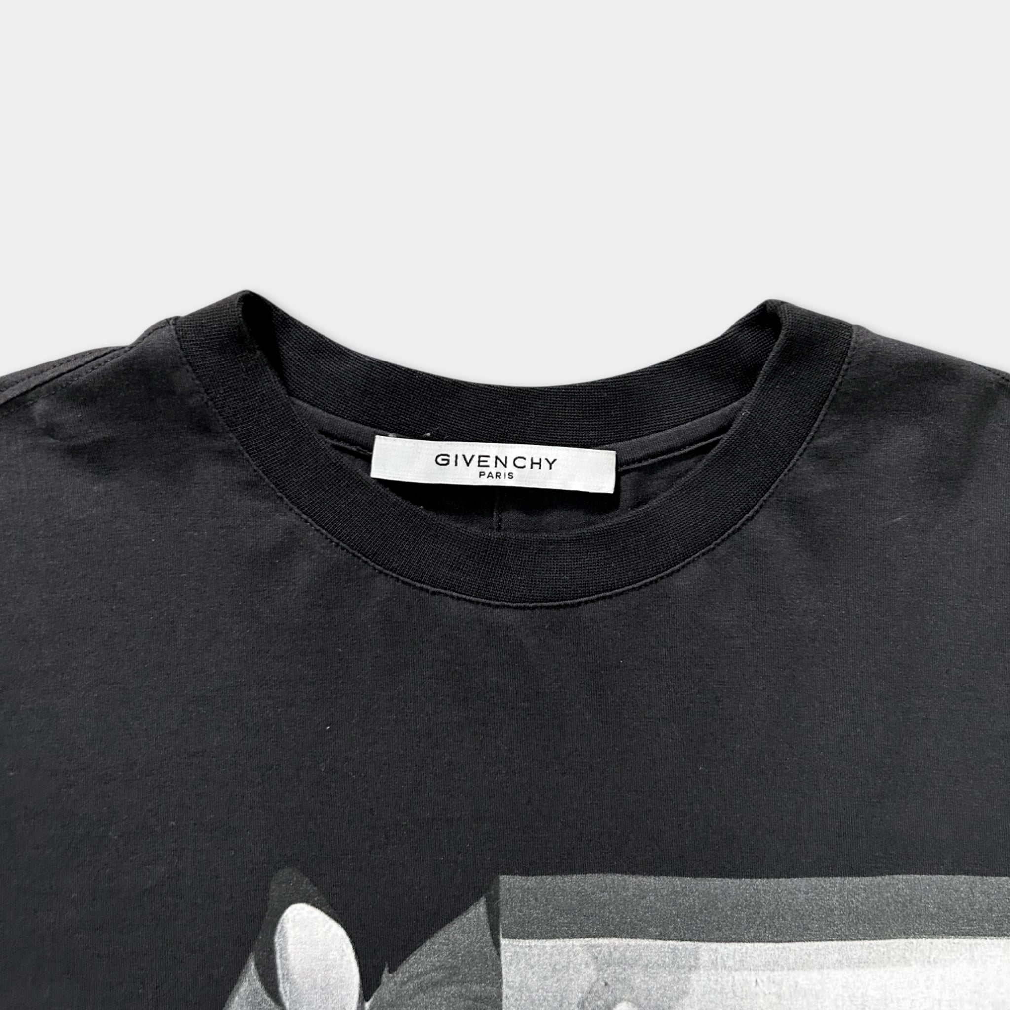 A black t-shirt with a label that reads "GIVENCHY" on the collar.