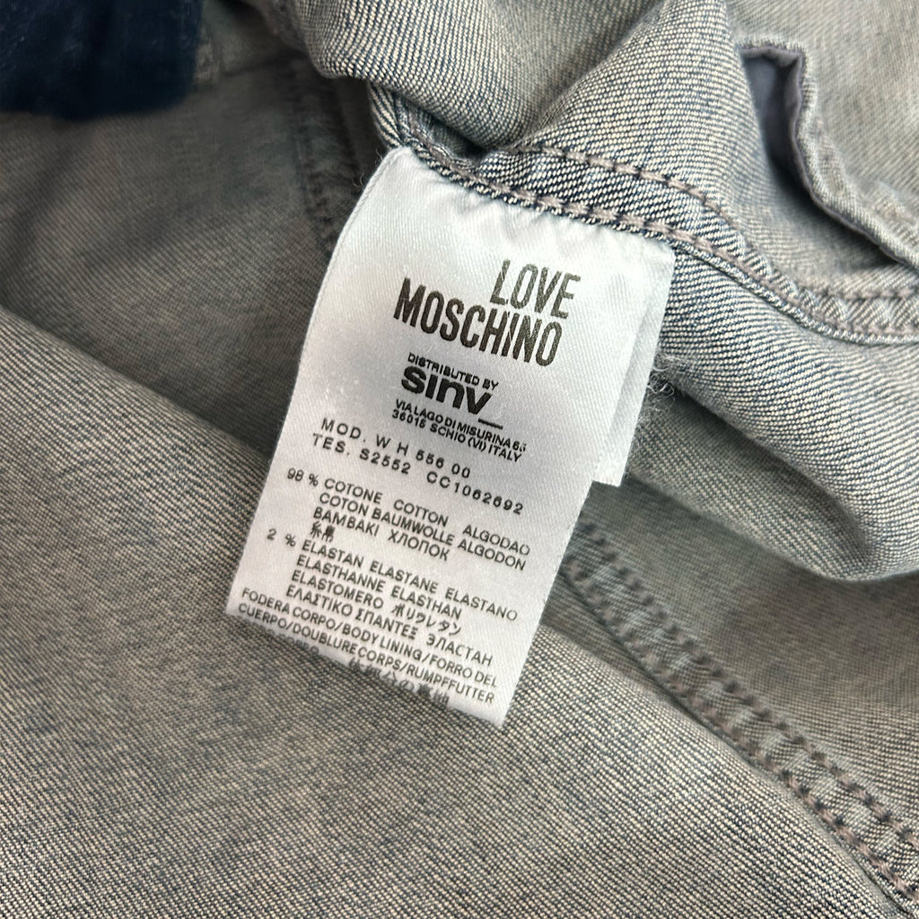 a close-up view of a label on a piece of clothing, likely a denim item, with text and details about the product.