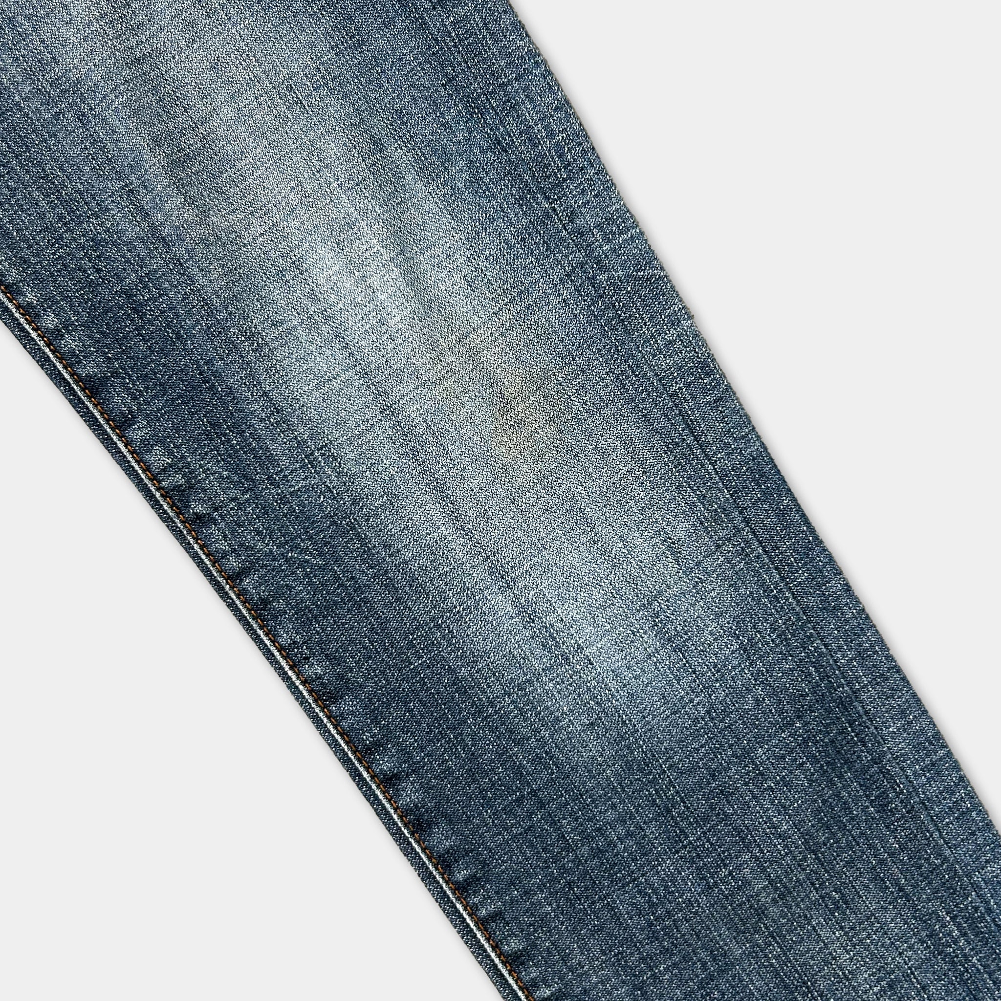 A close-up view of a pair of blue jeans, focusing on the fabric and stitching.