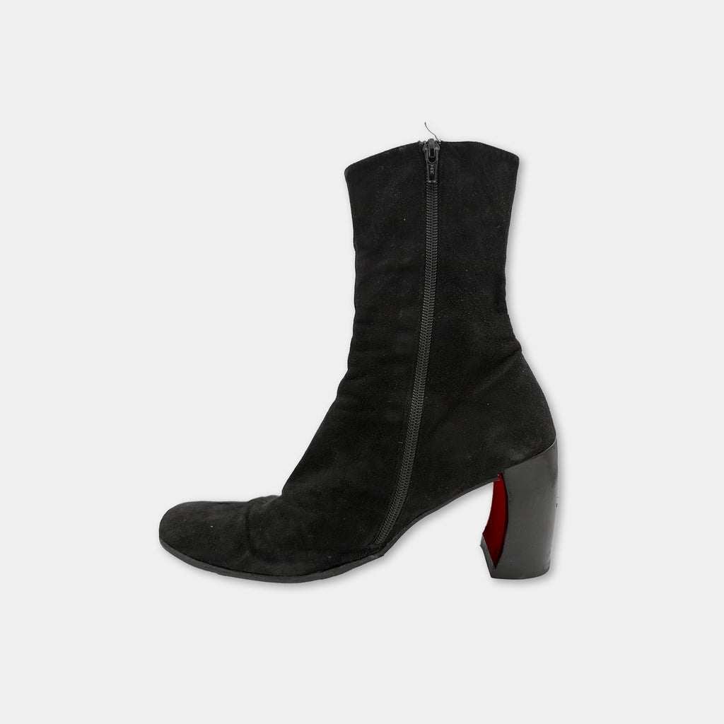A single black high-heeled boot with a red accent detail on the heel.