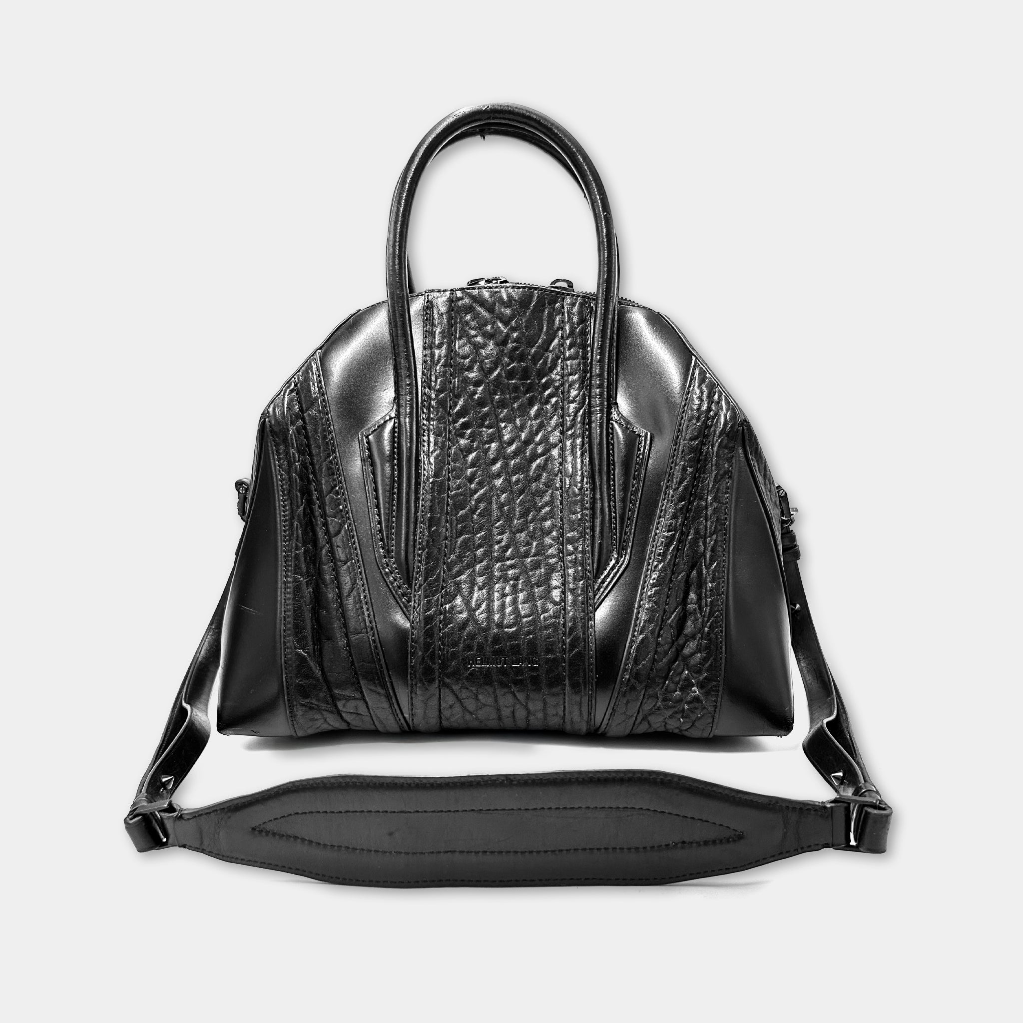 A black leather handbag with a textured pattern and a curved handle.