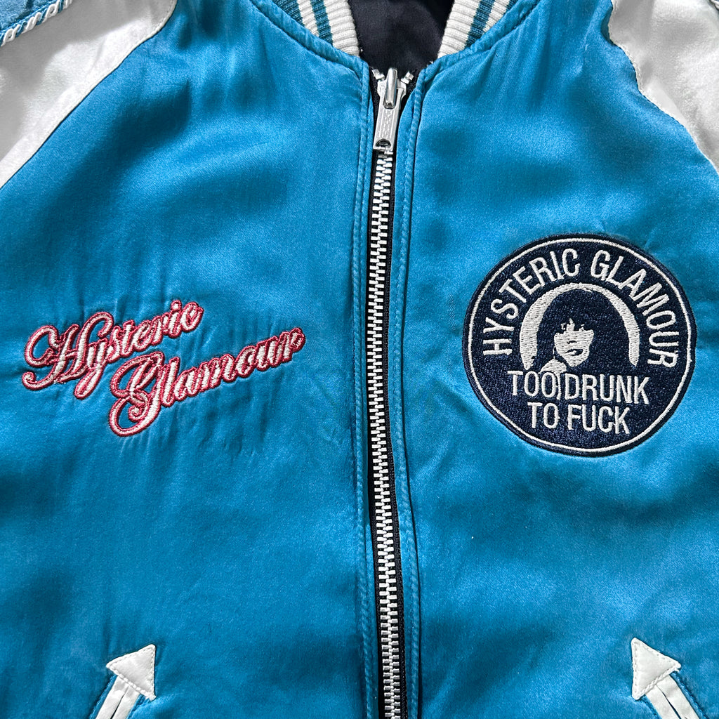 A close-up of a blue and white jacket with embroidered text and a circular patch on the front.