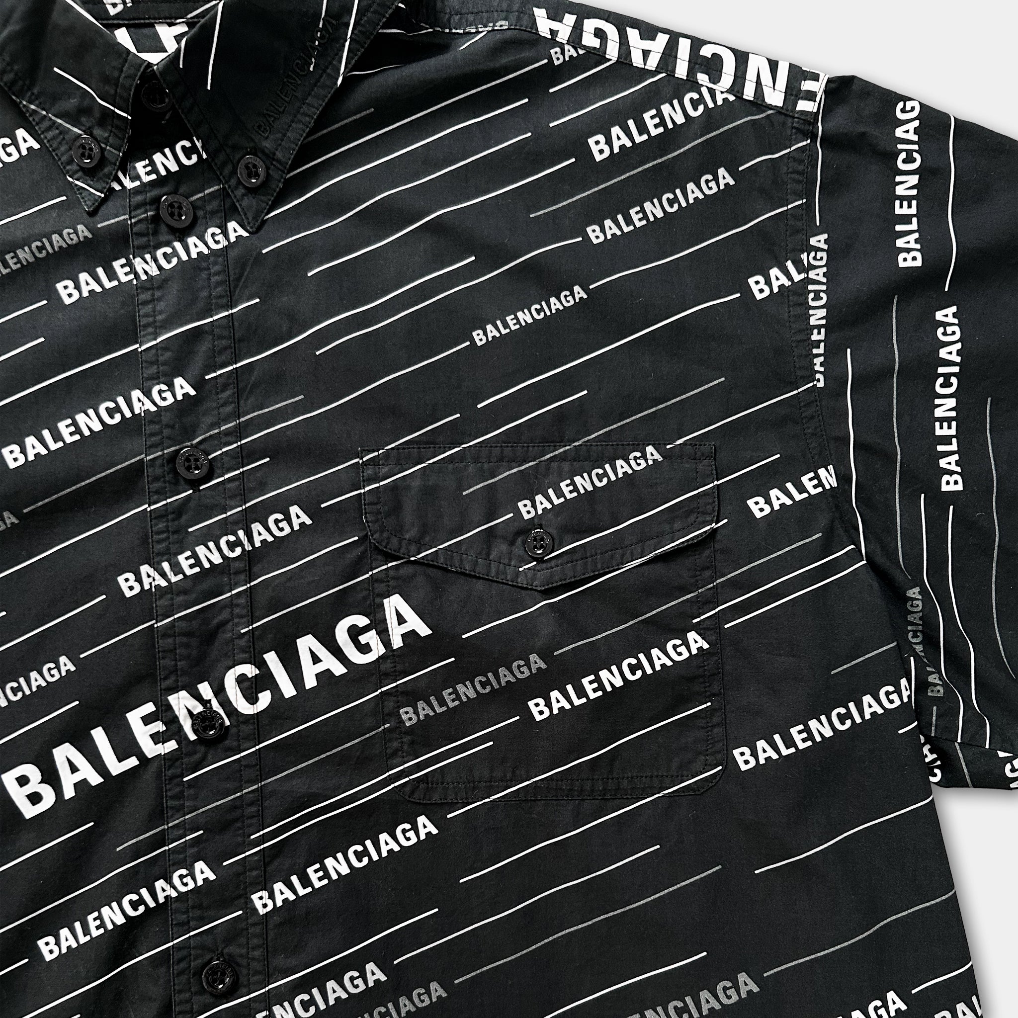 a close-up view of a black shirt with the word "BALENCIAGA" printed on it in white text.