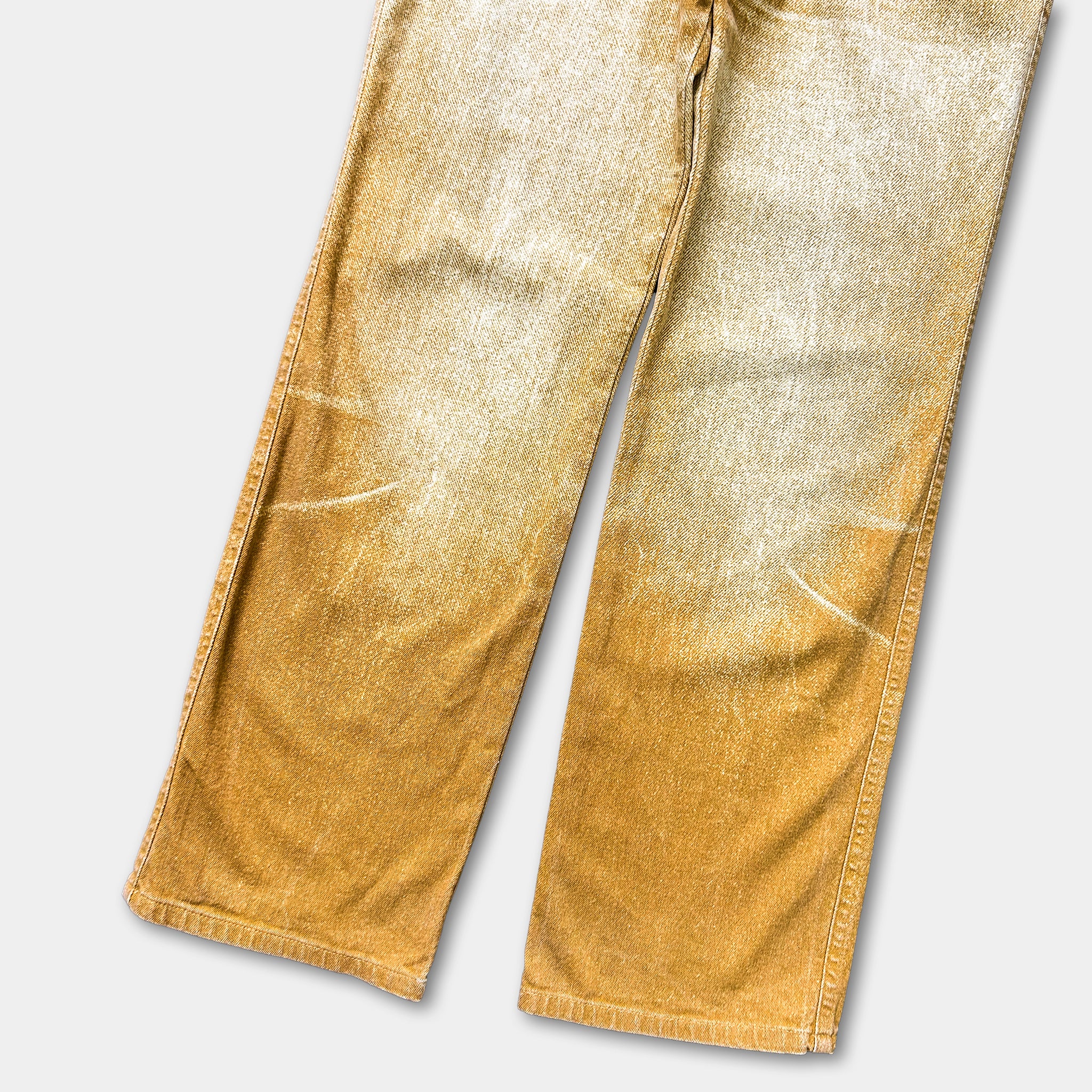 A pair of faded yellow denim jeans.