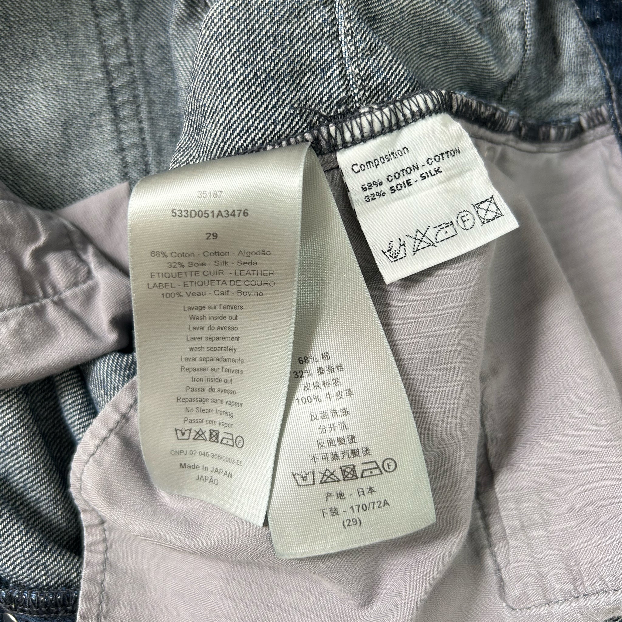 a pair of jeans with a label attached to the waistband, providing information about the jeans' material, care instructions, and washing details.
