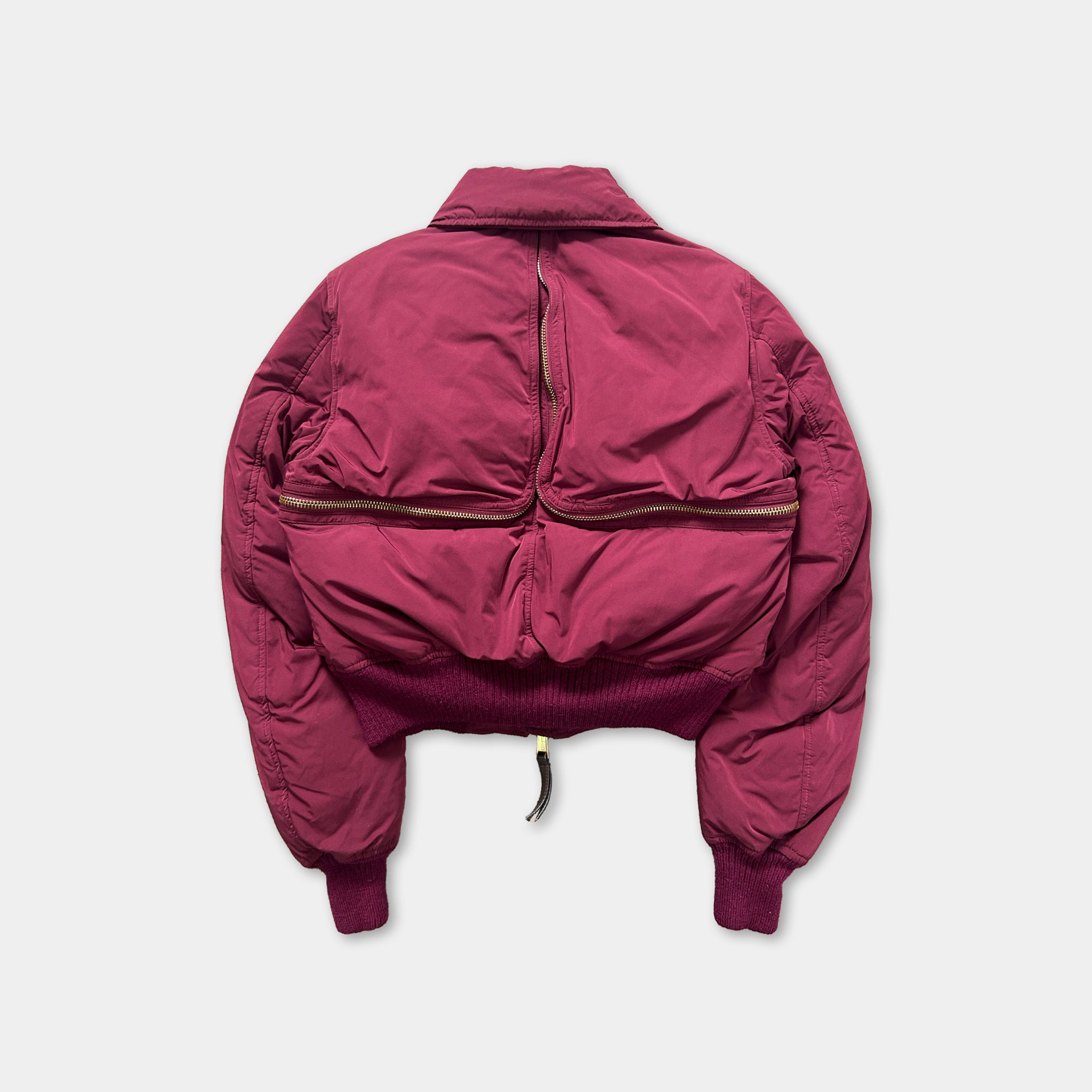 A maroon-colored jacket with a zipper running down the back, displayed against a white background.